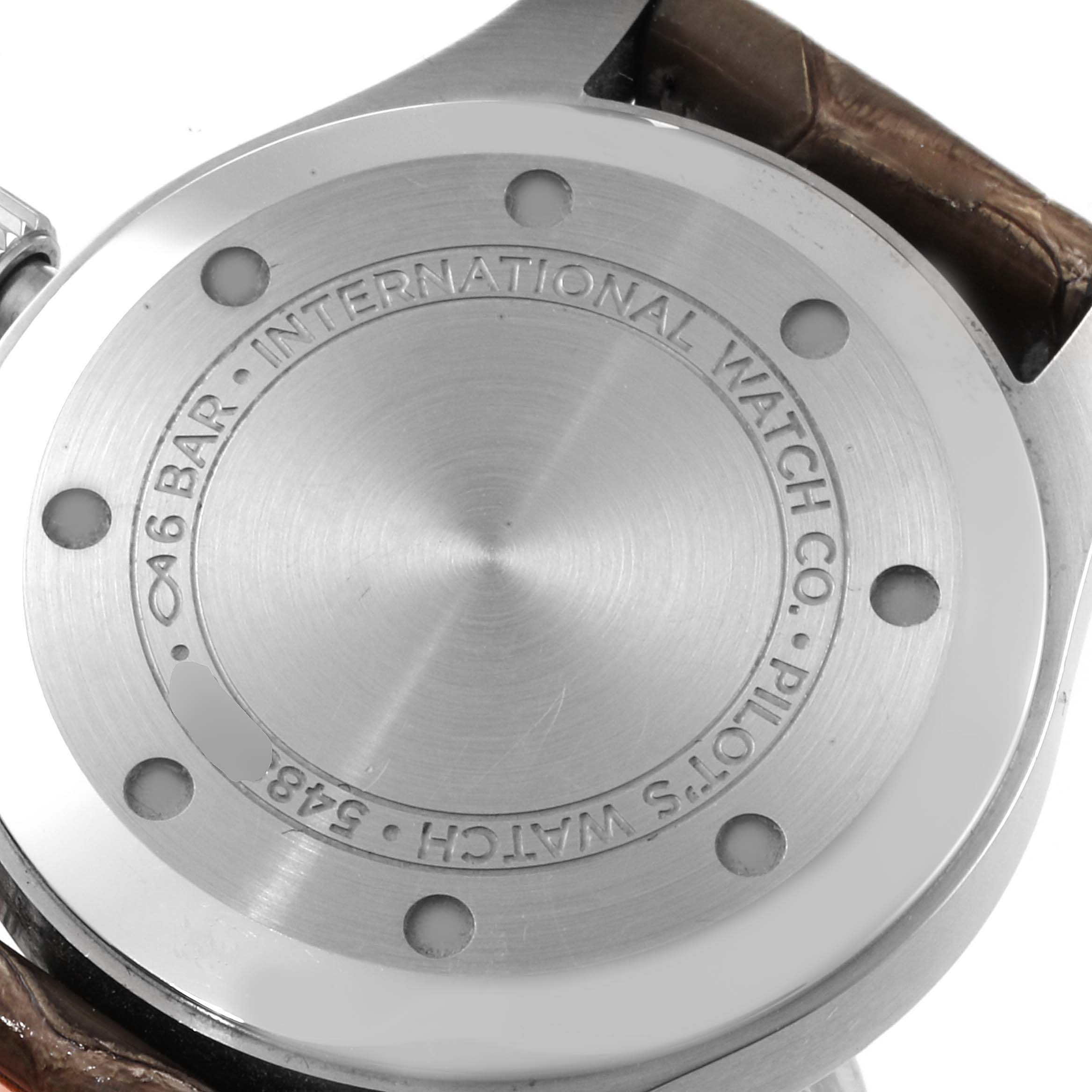 The image shows the back case of an IWC Pilot IW324001 Men's Stainless Steel Grey Dial IW324001 Men's Stainless Steel Grey Dial watch, highlighting its stainless steel surface with engraved details.