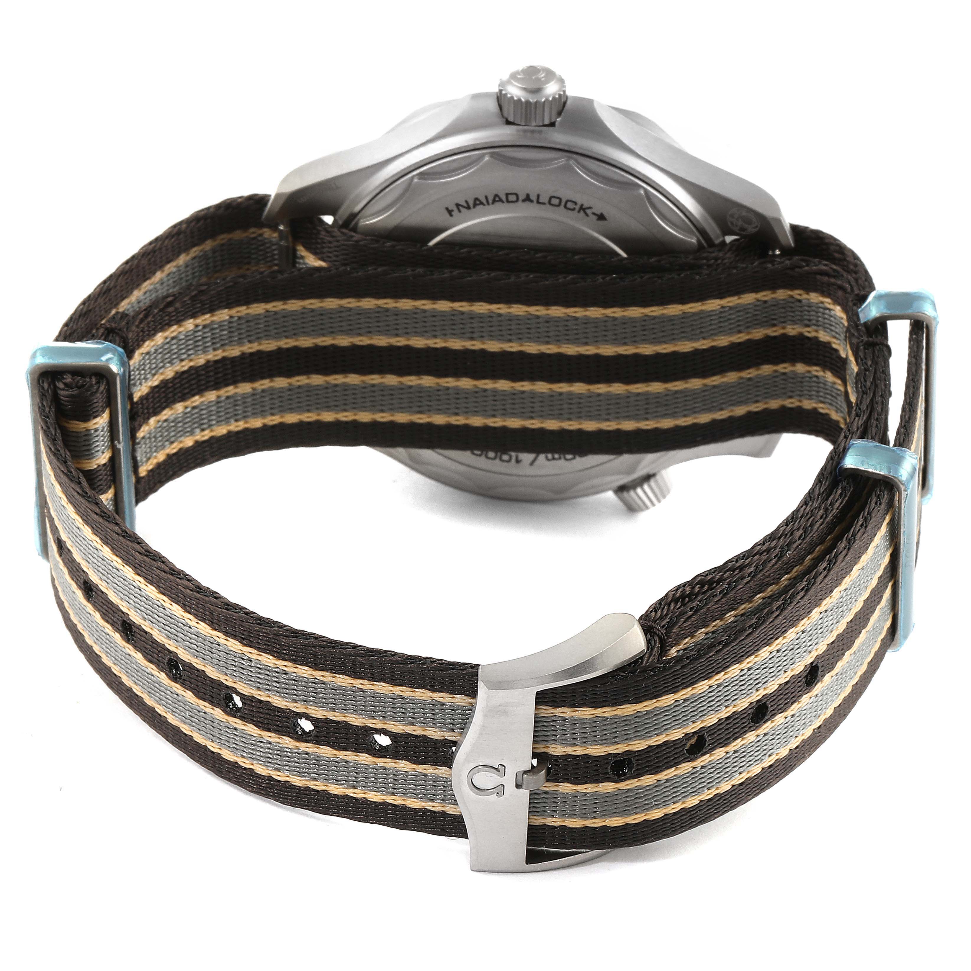 The image shows the back case and Nato strap of an Omega Seamaster 210.92.42.20.01.001 Men's Titanium Brown Dial 210.92.42.20.01.001 Men's Titanium Brown Dial watch, focusing on the Naiad Lock system and buckles.