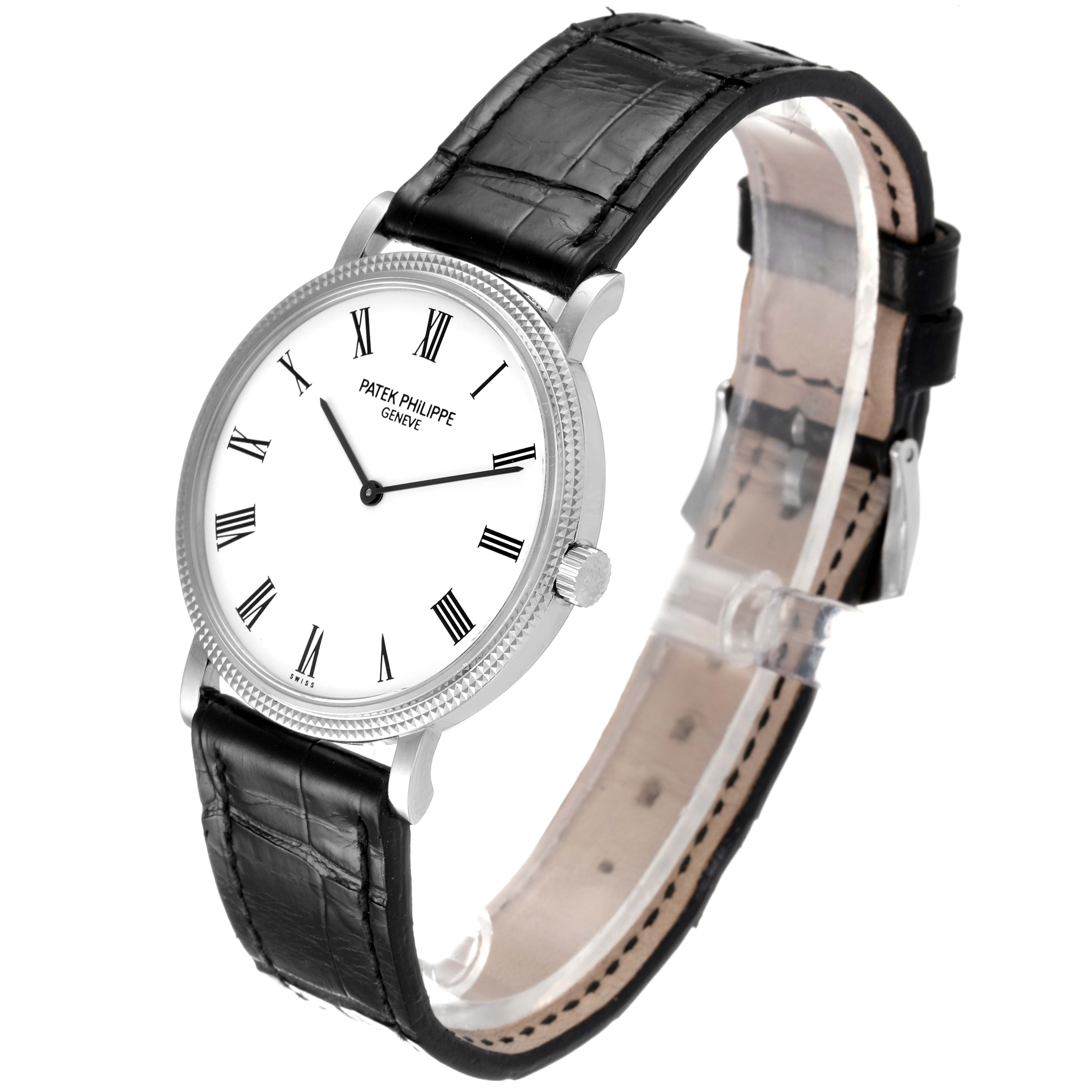 The image shows a Calatrava model by Patek Philippe at a slight side angle, displaying its face and black leather strap.