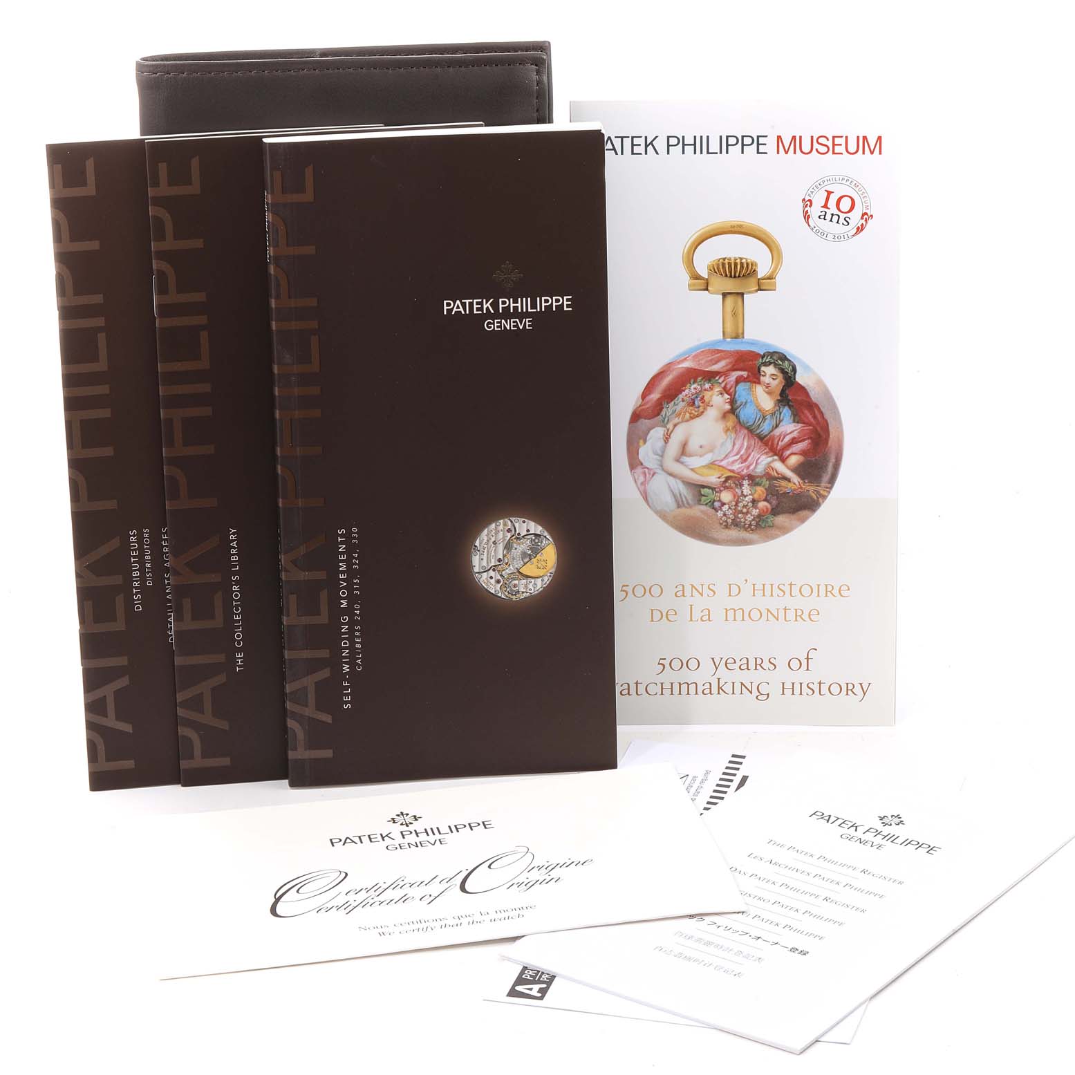 This image shows the documentation, certificates, and booklets for the Patek Philippe Calatrava 5120G Men's White Gold White Dial 5120G Men's White Gold White Dial watch, displayed from the front.