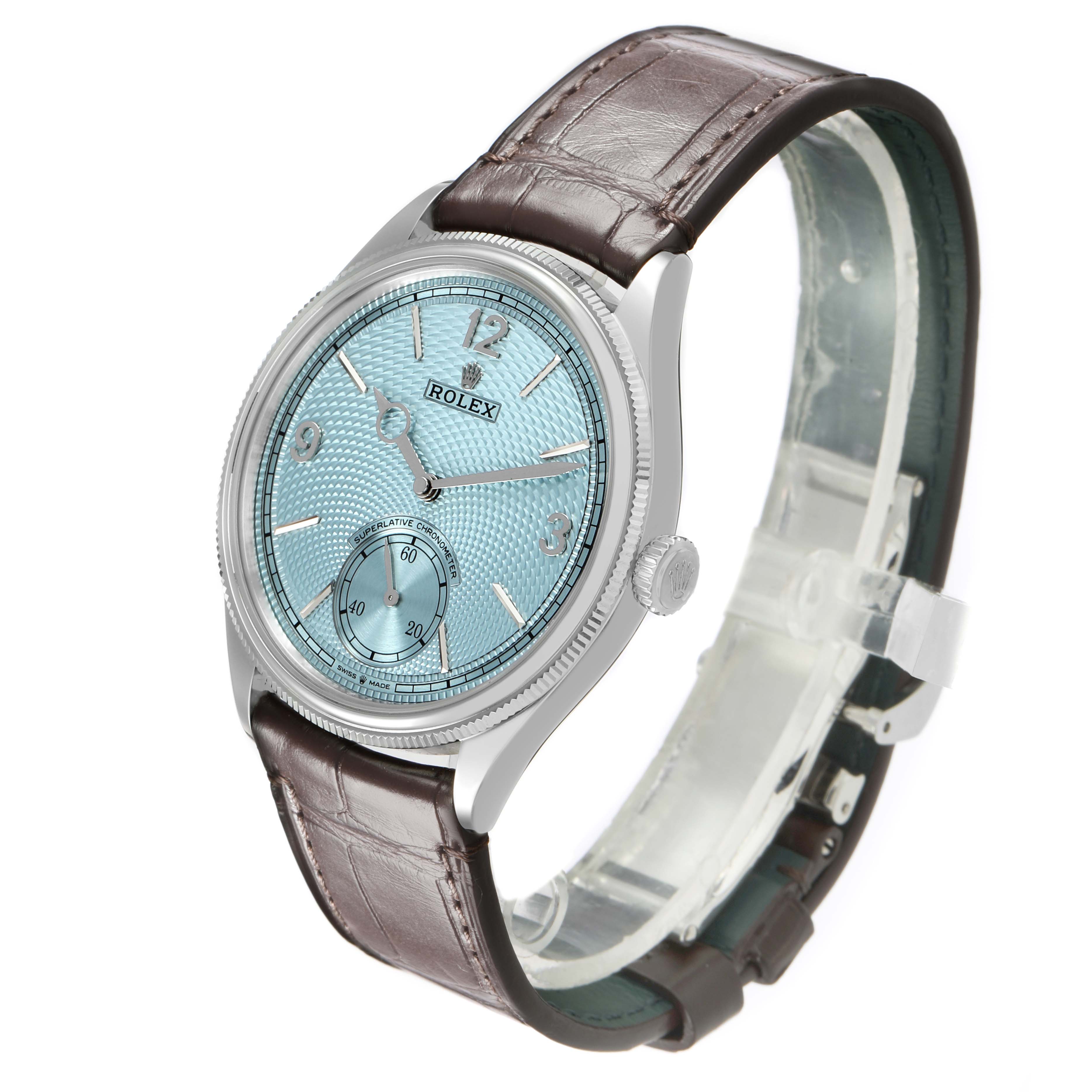 The Rolex 1908 52506 Men's Platinum Blue Dial watch is shown at an angled view, highlighting its blue dial, silver case, and brown leather strap.
