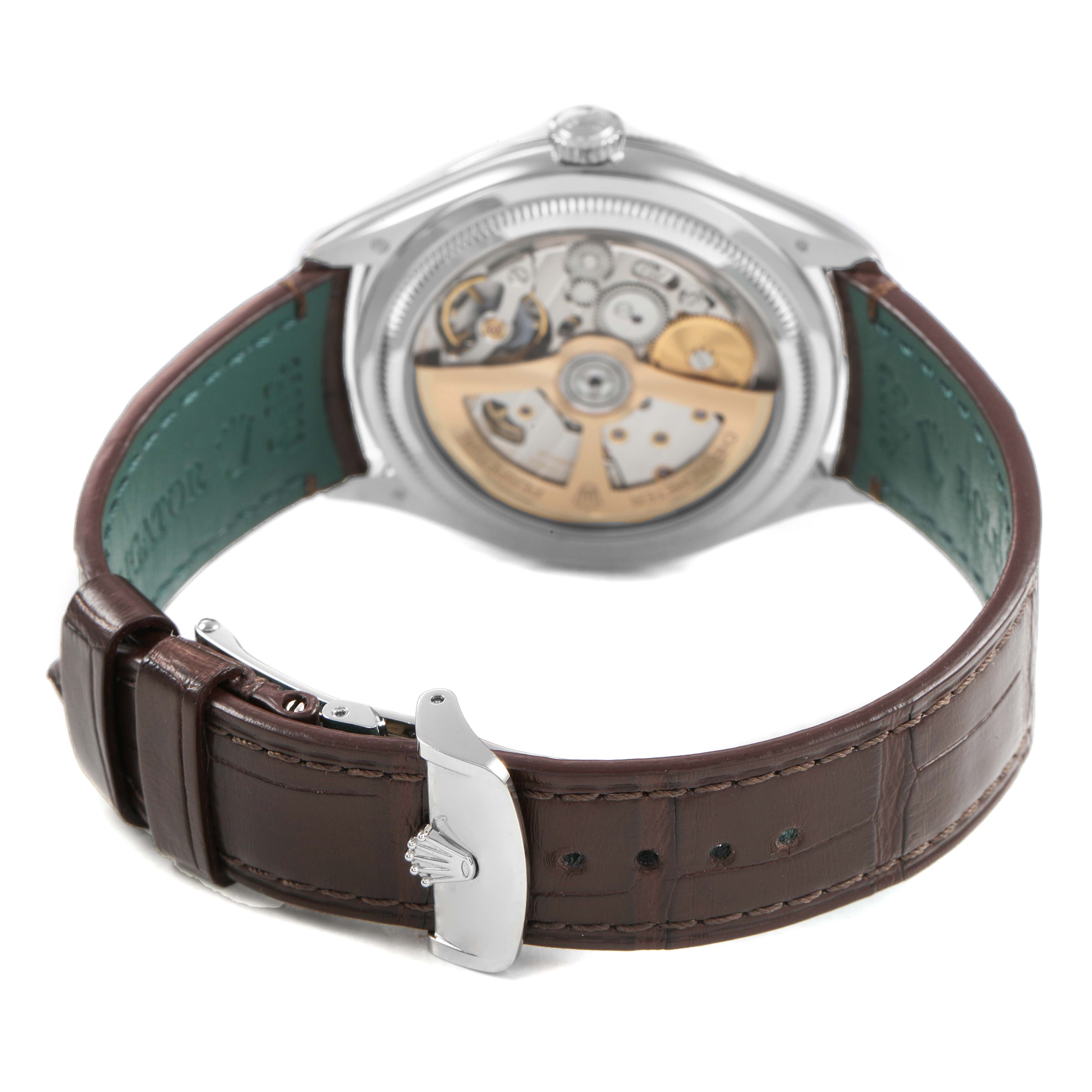 The image shows the back of a Rolex 1908 52506 Men's Platinum Blue Dial model, highlighting its open case back and movement, with a brown leather strap.