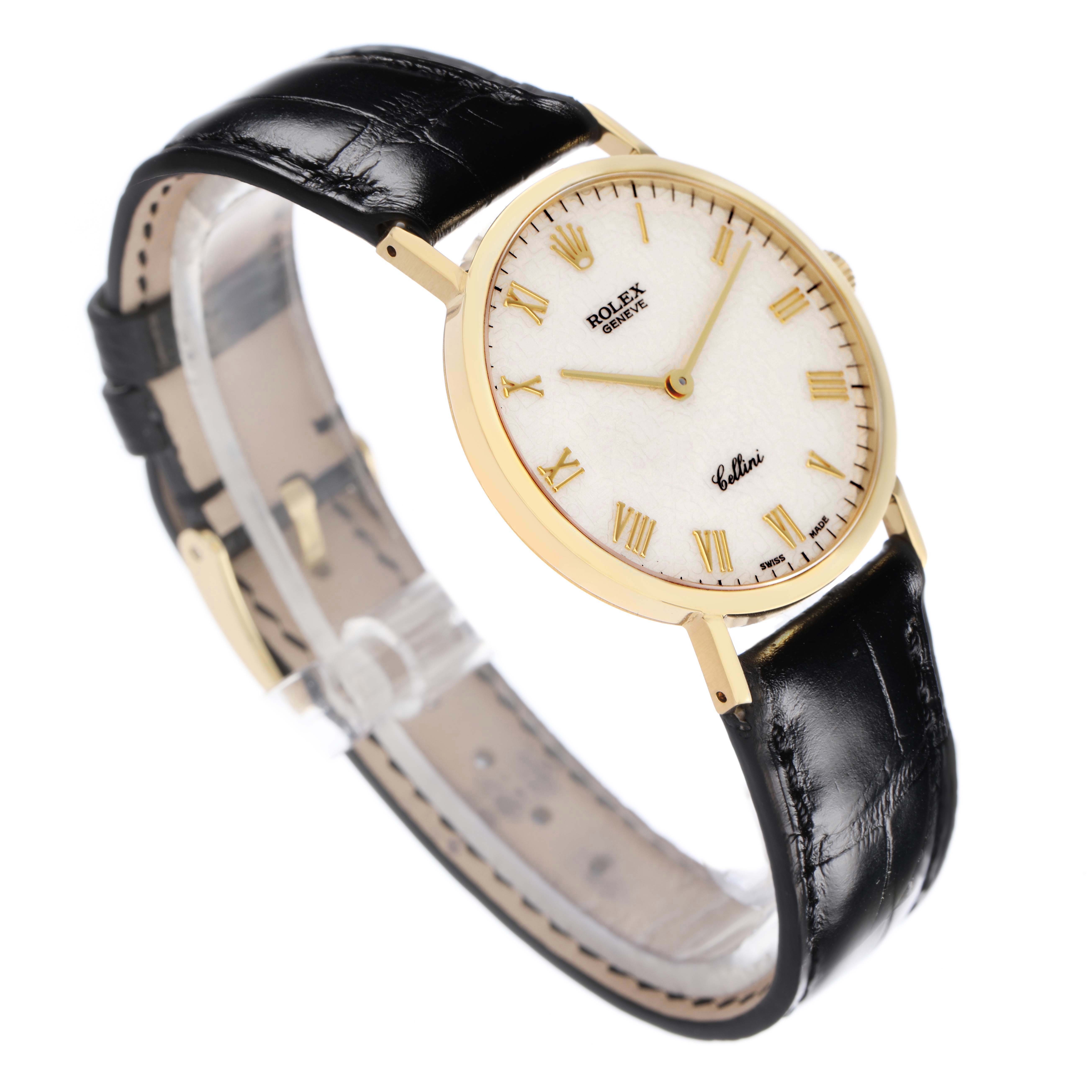 The Rolex Cellini 5112 Men
s Yellow Gold White Dial 5112 Men
s Yellow Gold White Dial watch is shown from a three-quarter angle, displaying the face, gold case, black leather strap, and side profile.