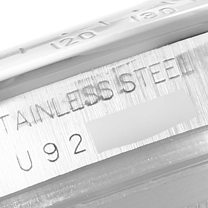 The image shows a close-up of the side of a Rolex Daytona 16520 Men
s Stainless Steel Black Dial 16520 Men
s Stainless Steel Black Dial watch case, highlighting the stainless steel material and partial serial number.