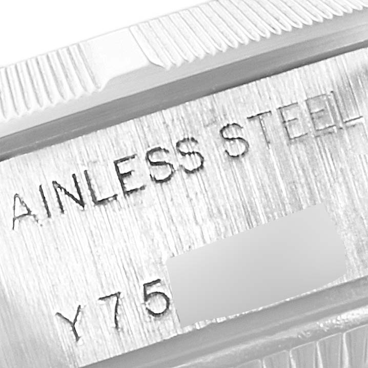 This close-up image shows the engraved "STAINLESS STEEL" and part of the serial number on the case of a Rolex Date 79190 Women's Stainless Steel Black Dial 79190 Women's Stainless Steel Black Dial model watch.