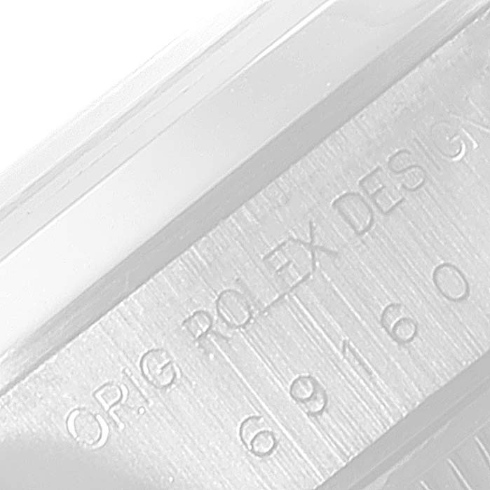 This image shows a close-up of the engraved serial number on a Rolex Date 69160 Women's Stainless Steel Blue Dial 69160 Women's Stainless Steel Blue Dial model watch case.