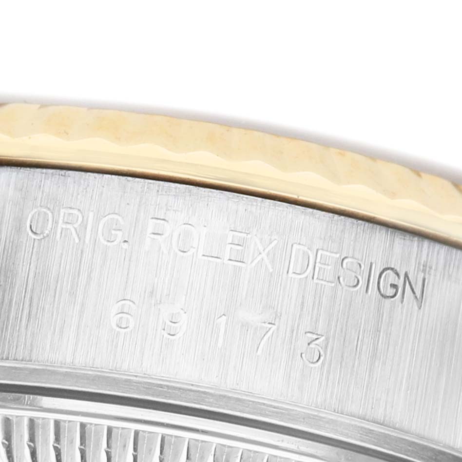 The image shows a close-up of the side of a Rolex Datejust 69173 Women's Steel and Gold (two tone) Champagne Dial watch, highlighting the engraved model number and design details.