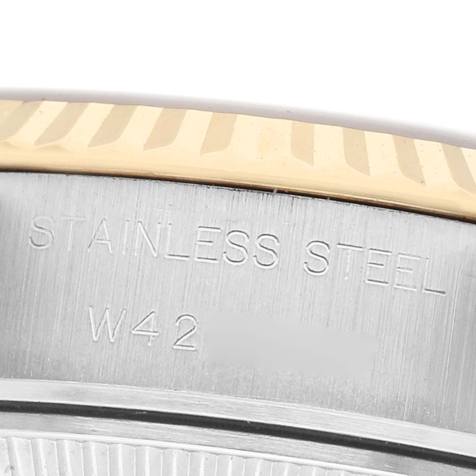 The image shows a close-up of the stainless steel casing and fluted bezel of a Rolex Datejust 69173 Women's Steel and Gold (two tone) Silver Dial watch.
