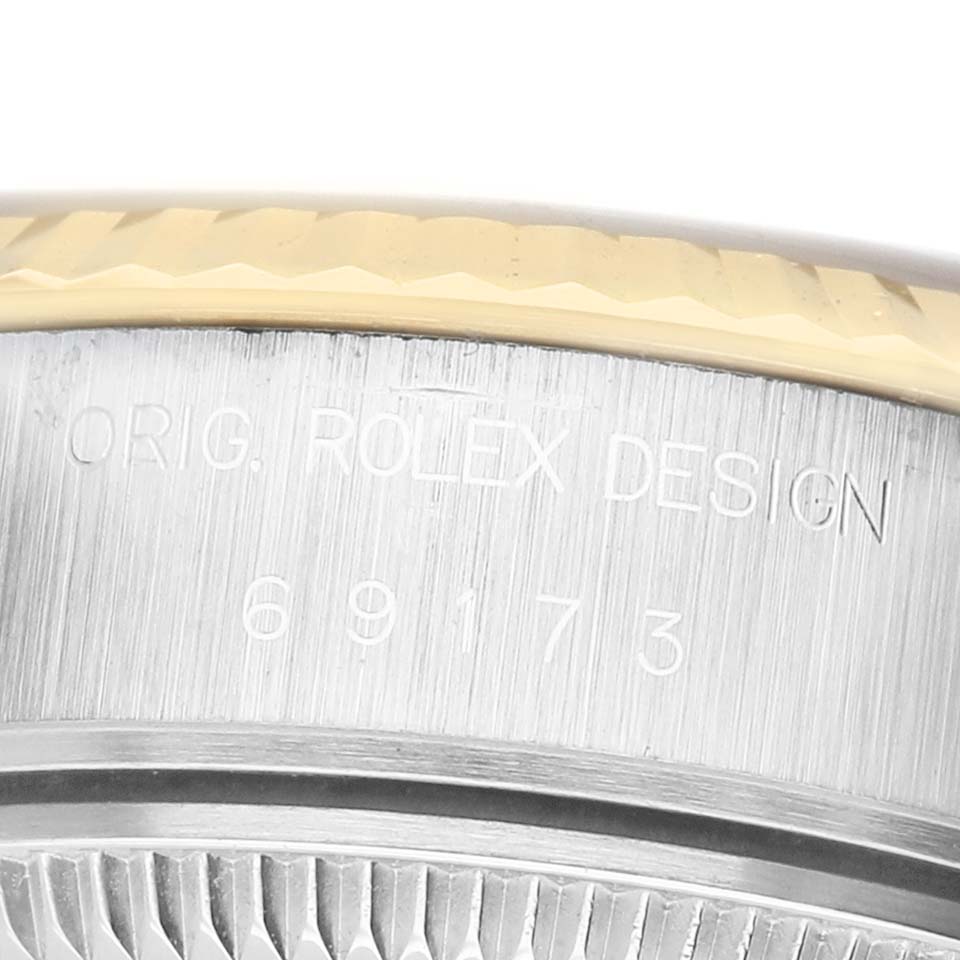 This close-up image shows the engraved side of the Rolex Datejust 69173 Women's Steel and Gold (two tone) Silver Dial case with part of the bezel visible.