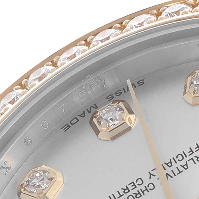 The image shows a close-up of the bezel and dial of a Rolex Mid-Size 178383 Women's Steel and Gold (two tone) Silver Dial 178383 Women's Steel and Gold (two tone) Silver Dial watch, highlighting its diamond markers and gold accent.