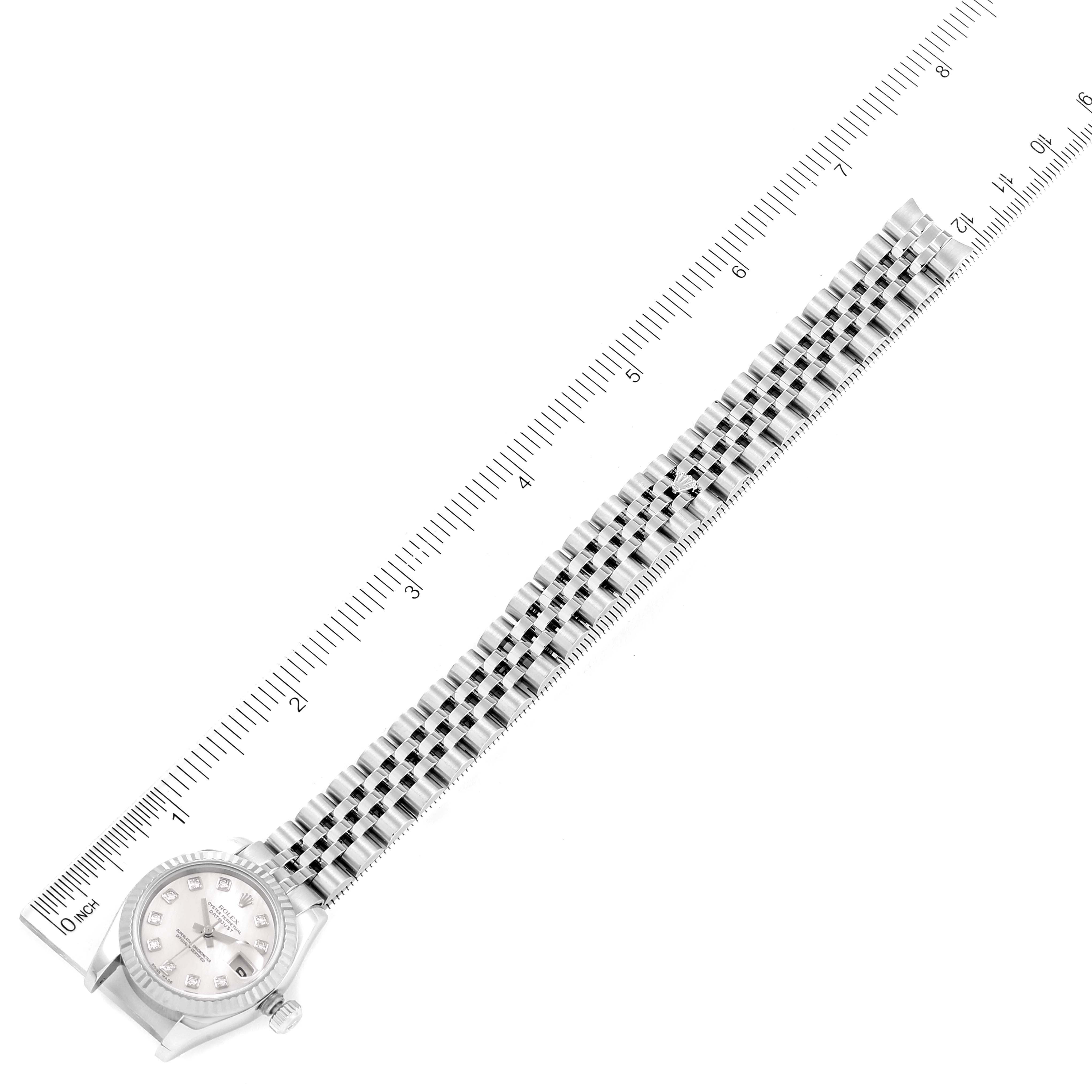 This image shows a Rolex Datejust 179174 Women's Stainless Steel Mother of Pearl Dial 179174 Women's Stainless Steel Mother of Pearl Dial watch laid flat beside a ruler, displaying the full bracelet and watch face.
