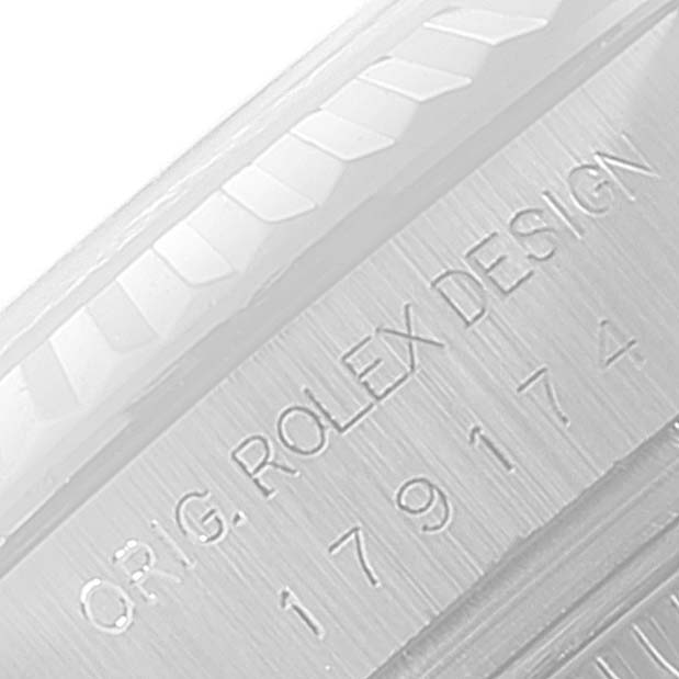 This image shows a close-up of the engraved serial number and fluted bezel on a Rolex Datejust 179174 Women's Stainless Steel Mother of Pearl Dial 179174 Women's Stainless Steel Mother of Pearl Dial watch.