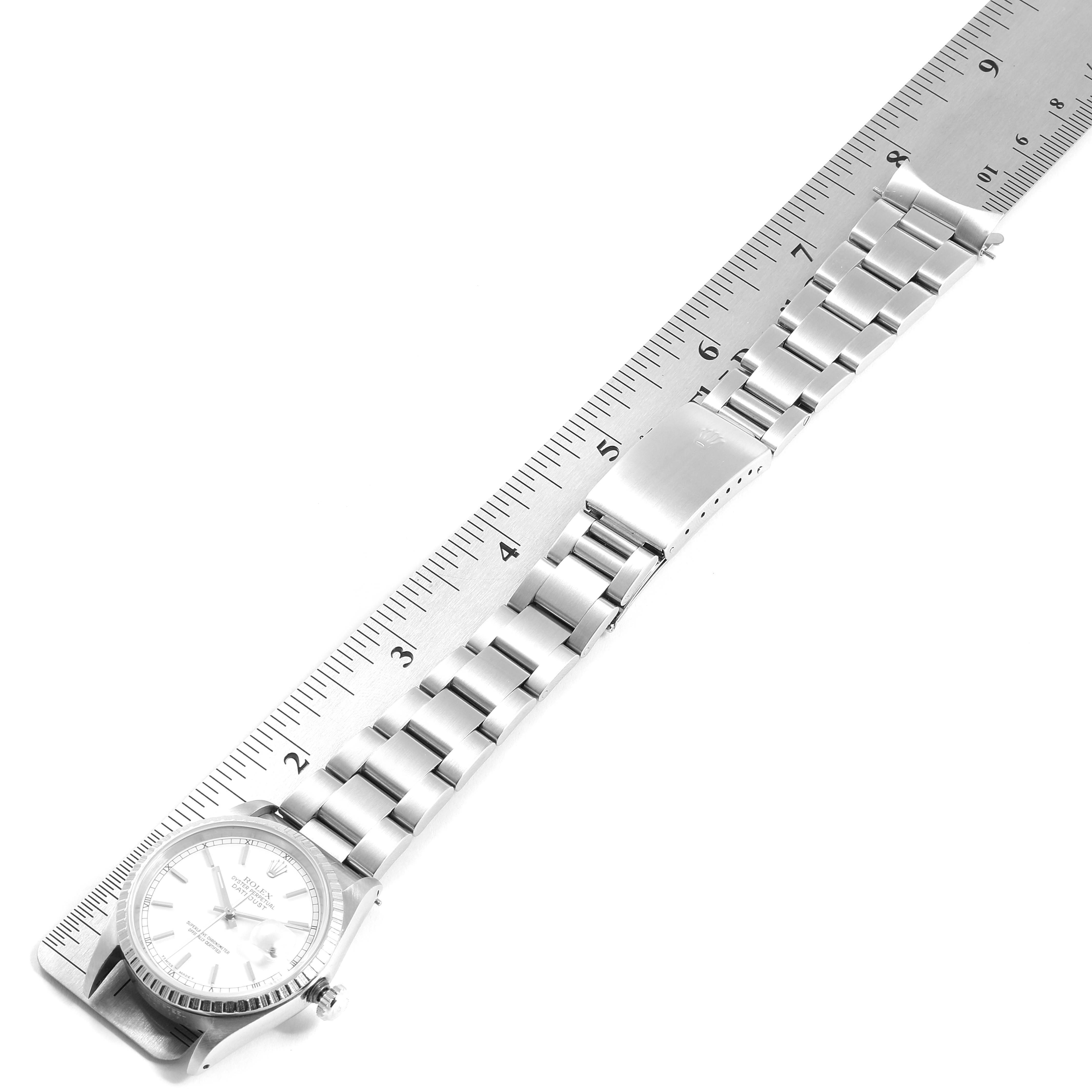This image shows a Rolex Datejust 16220 Men's Stainless Steel White Dial 16220 Men's Stainless Steel White Dial watch laid flat with a ruler next to it, highlighting its bracelet and clasp.