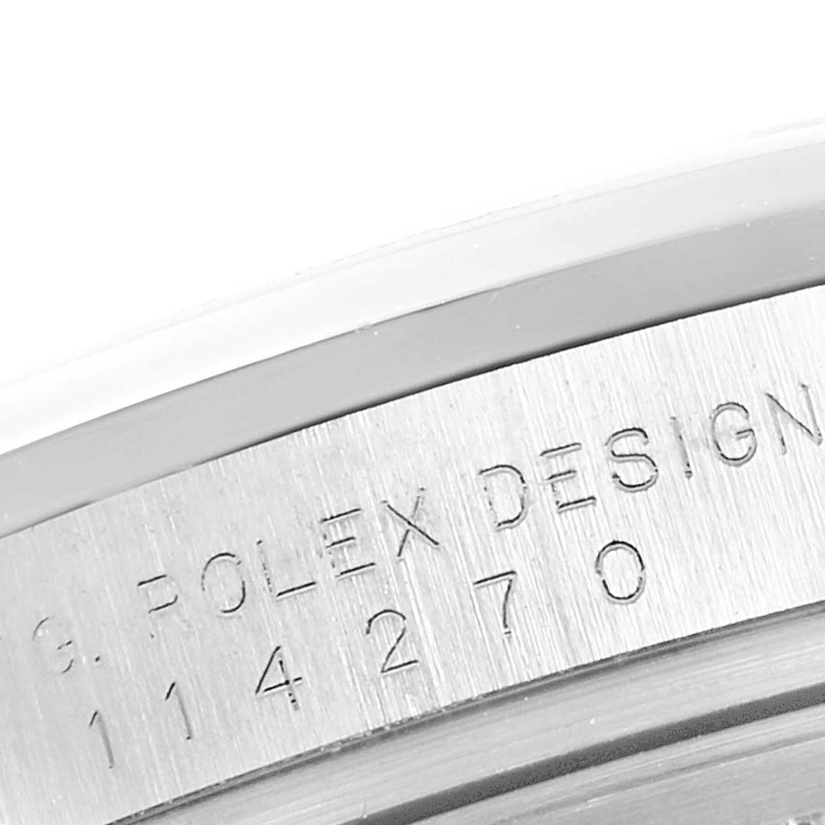 The image shows a close-up of the side case of a Rolex Explorer 114270 Men
s Stainless Steel Black Dial 114270 Men
s Stainless Steel Black Dial watch, featuring an engraved serial number and "ROLEX DESIGN."