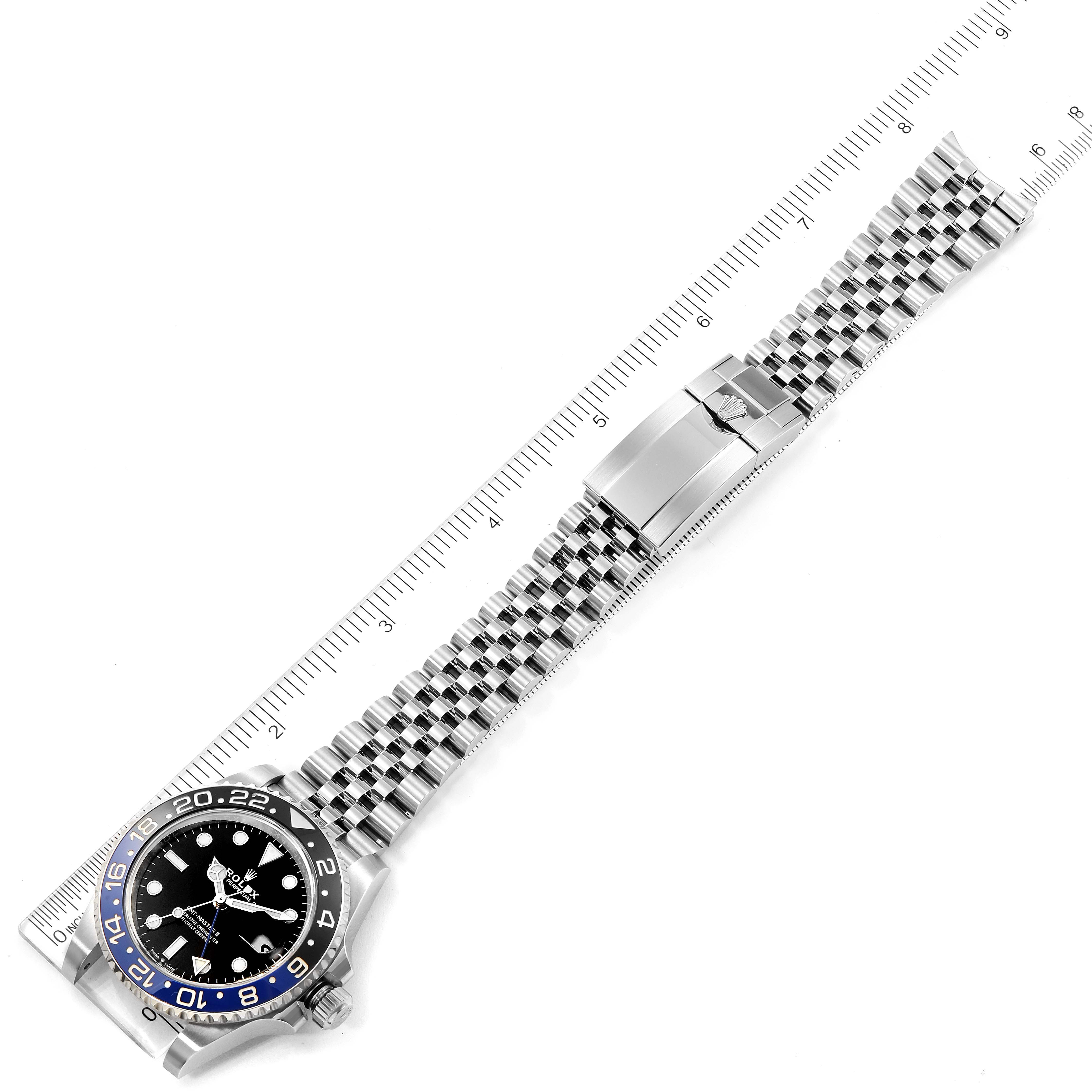 This image shows the front view of a Rolex GMT-Master 126710 Men
s Stainless Steel Black Dial 126710 Men
s Stainless Steel Black Dial watch with its stainless-steel bracelet and clasp, alongside a ruler for scale.