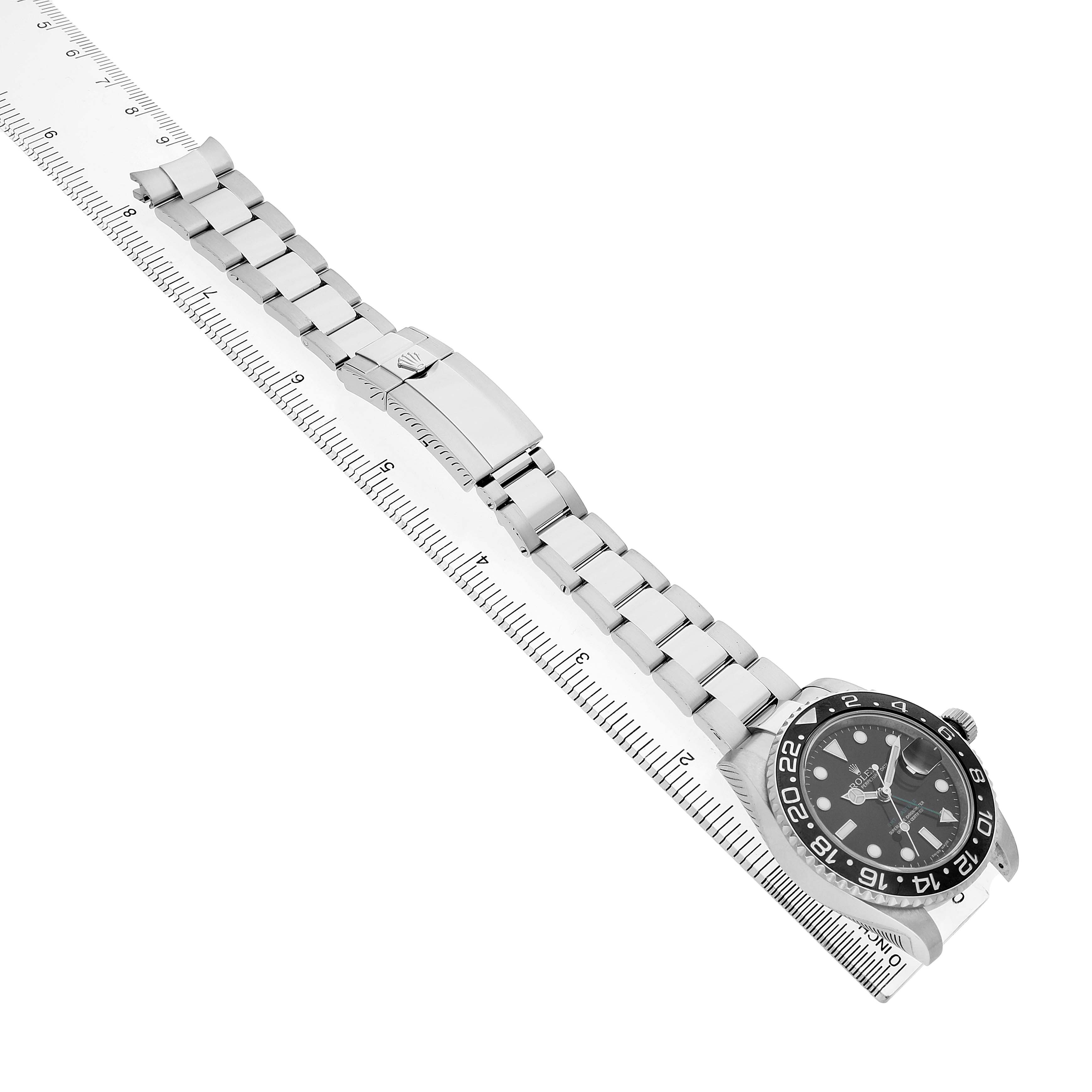 The Rolex GMT-Master 116710 Men's Stainless Steel Black Dial watch is shown at a diagonal angle, highlighting its face, bezel, bracelet, and clasp alongside a ruler.