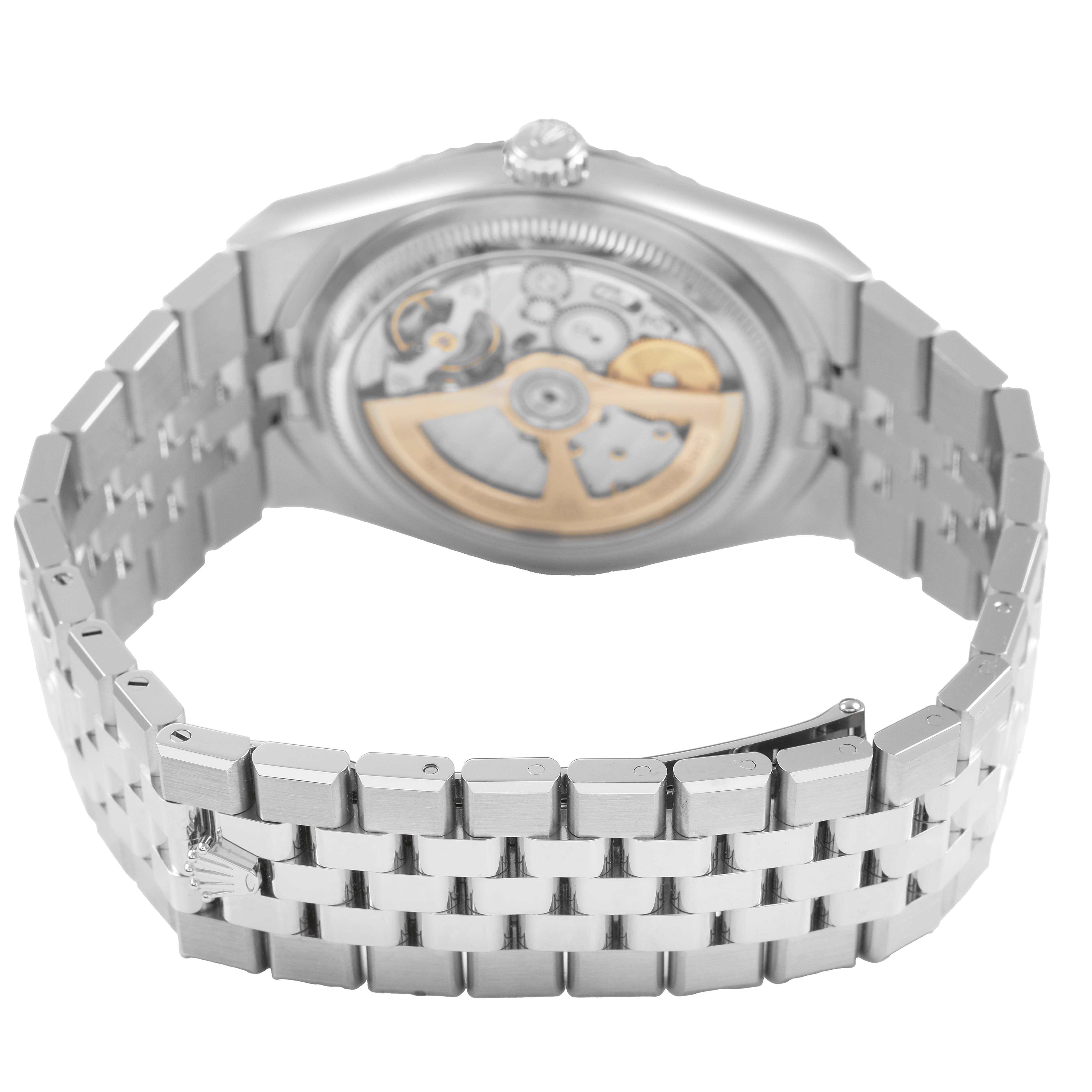 The Rolex Land-Dweller watch is shown from the back, displaying its open case back and metal bracelet.