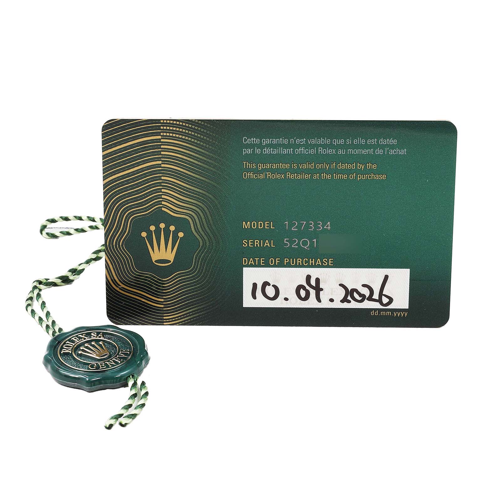 The image shows a Rolex Land-Dweller warranty card and tag, displaying model and serial numbers.