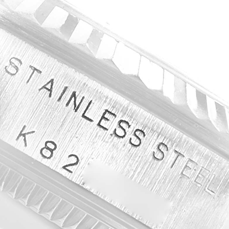 The image shows a close-up of the side of a mid-size Rolex watch case, highlighting the "STAINLESS STEEL" engraving and part of the bezel.