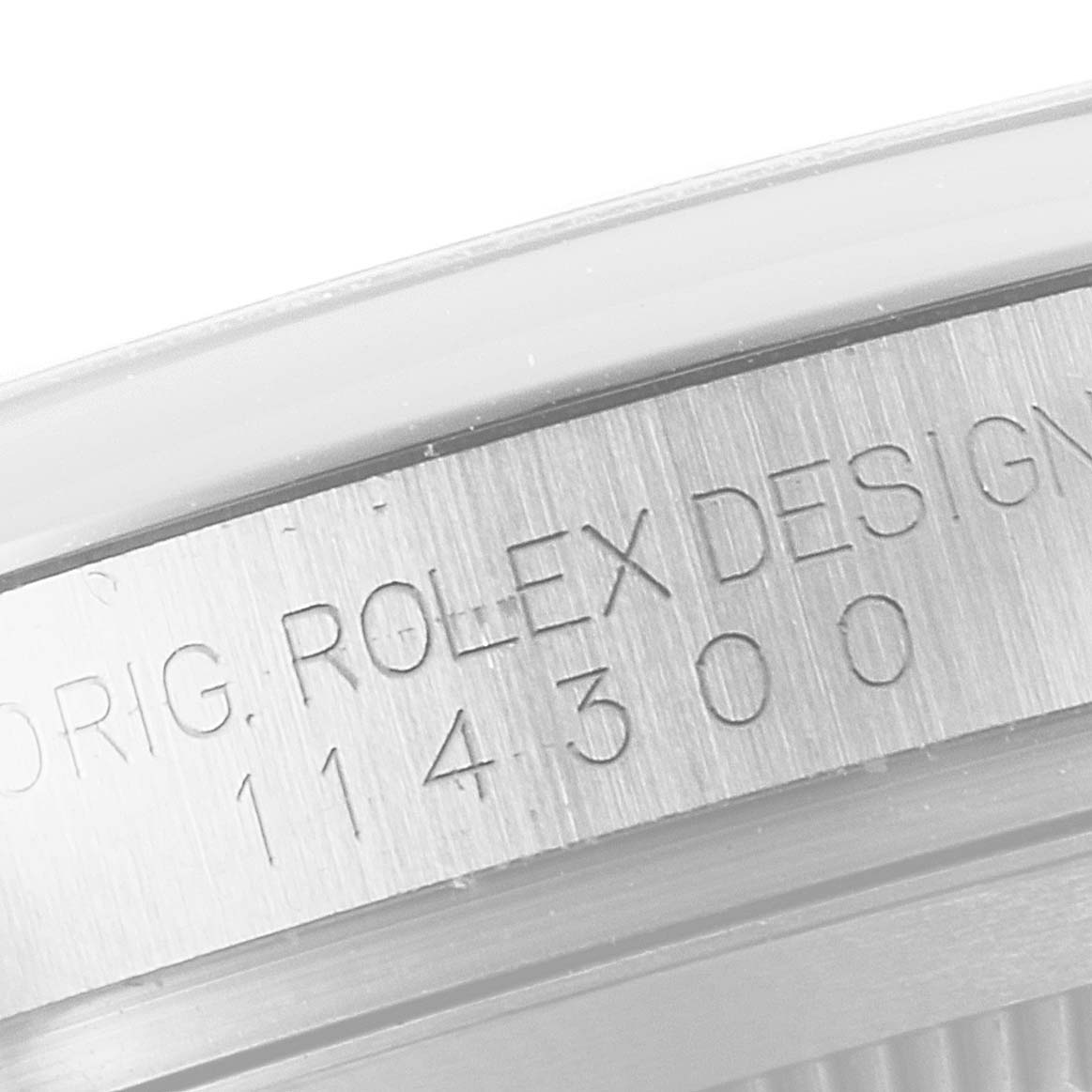 The image shows a close-up of the engraved case back of a Rolex Oyster Perpetual 114300 Men's Stainless Steel Silver Dial 114300 Men's Stainless Steel Silver Dial model with the design number 114300.