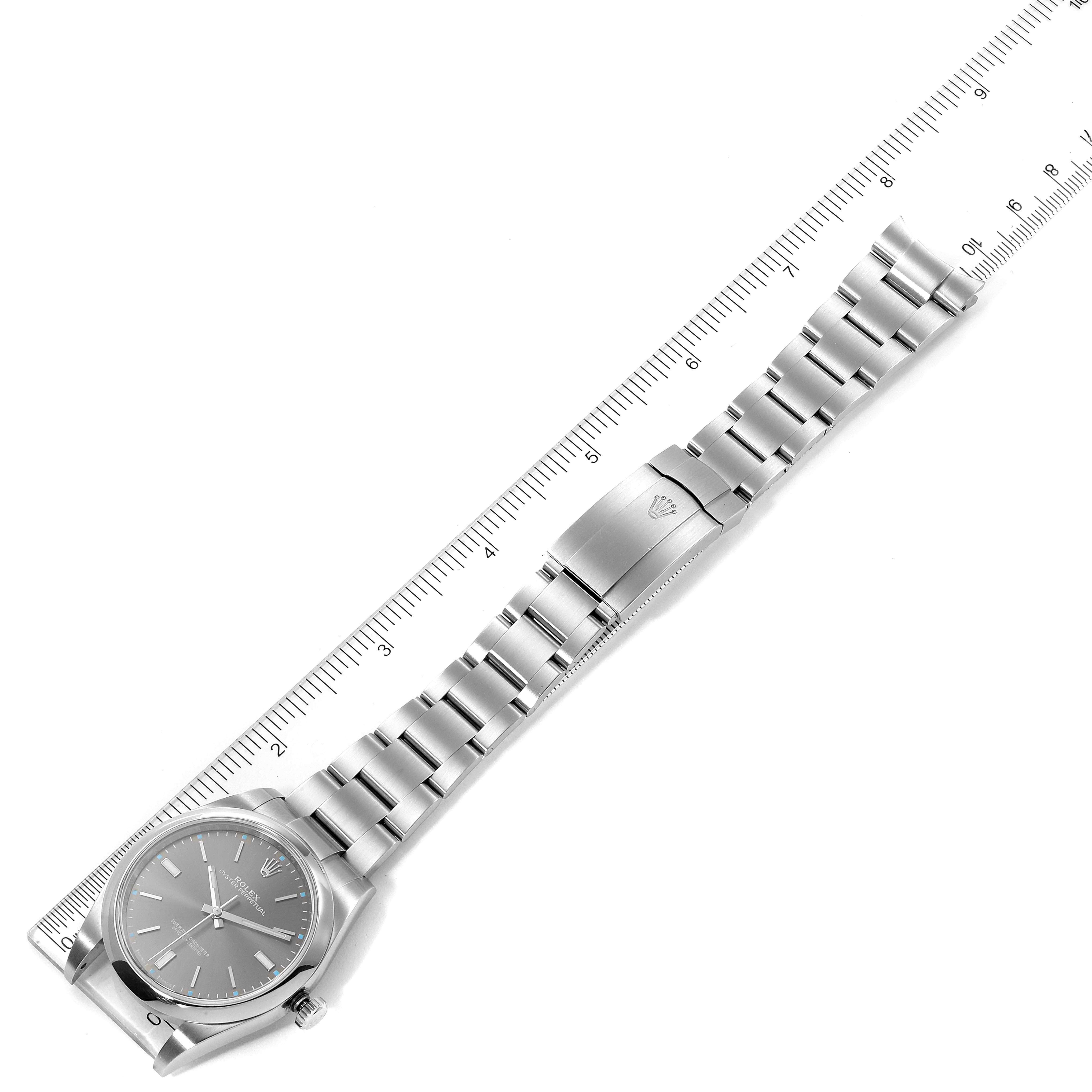 This Rolex Oyster Perpetual 114300 Men's Stainless Steel Silver Dial 114300 Men's Stainless Steel Silver Dial watch is shown from above, displaying the entire bracelet and face with a ruler for scale.