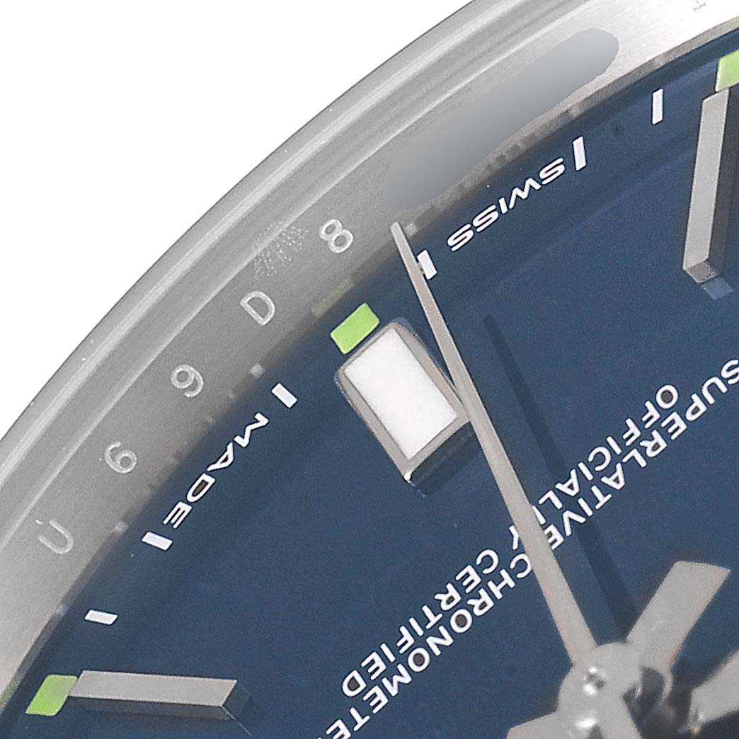 The image shows a close-up of the dial and part of the bezel of the Rolex Oyster Perpetual 114300 Men
s Stainless Steel Blue Dial 114300 Men
s Stainless Steel Blue Dial watch.