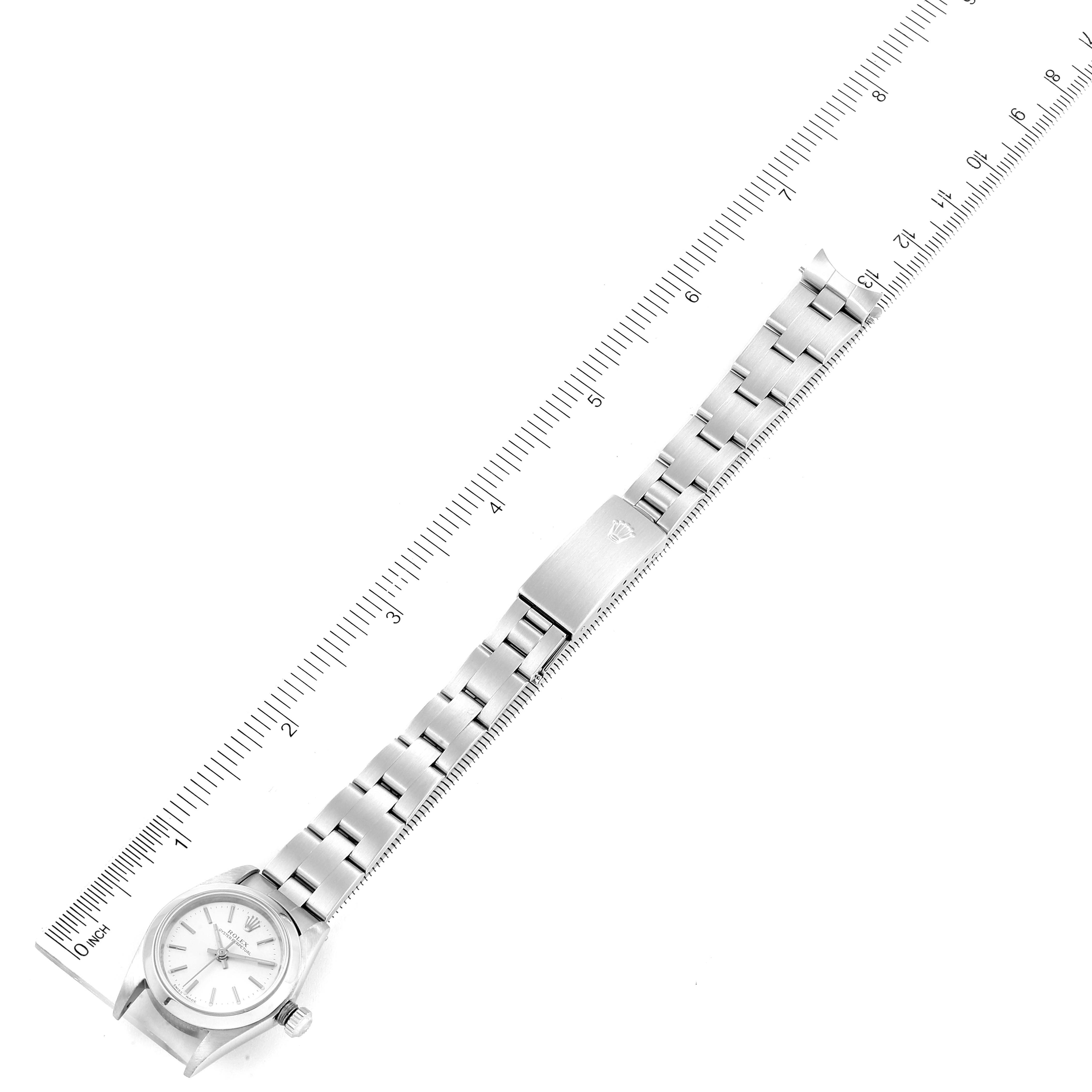 This image shows a top view of a Rolex Oyster Perpetual 76080 Women's Stainless Steel Silver Dial 76080 Women's Stainless Steel Silver Dial watch, featuring the face, bracelet, and clasp, alongside a measuring ruler.