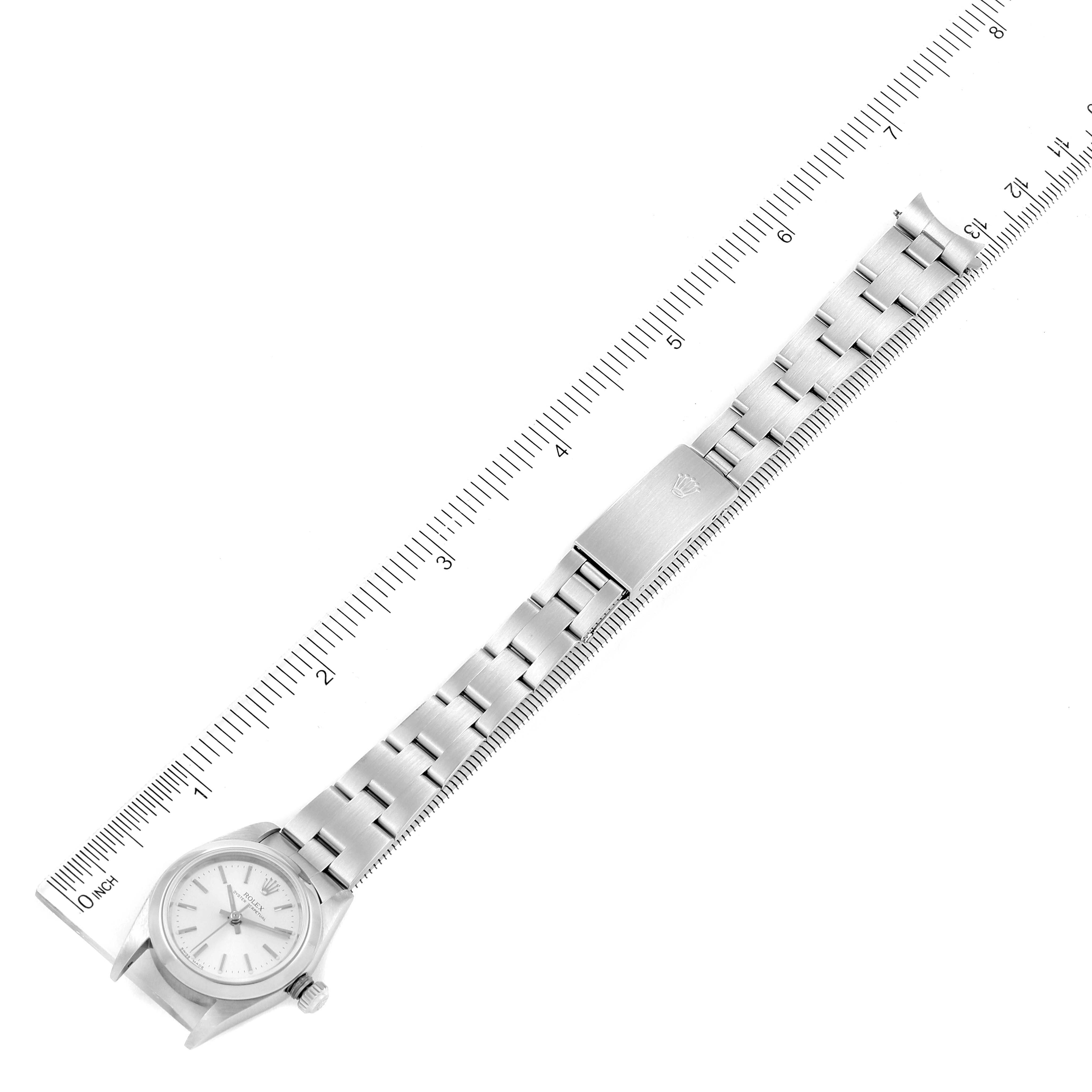 This top-down image shows the full length, clasp, and face of the Rolex Oyster Perpetual 76080 Women
s Stainless Steel Silver Dial 76080 Women
s Stainless Steel Silver Dial watch aligned with a ruler for measurement.