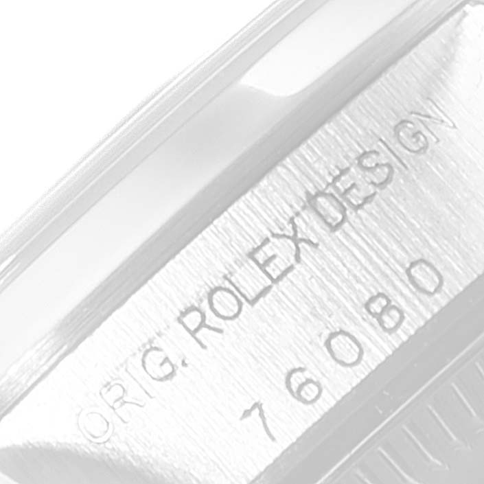 This image shows a close-up of the engraved side of a Rolex Oyster Perpetual 76080 Women
s Stainless Steel Silver Dial 76080 Women
s Stainless Steel Silver Dial watch displaying "ORIG. ROLEX DESIGN 76080."