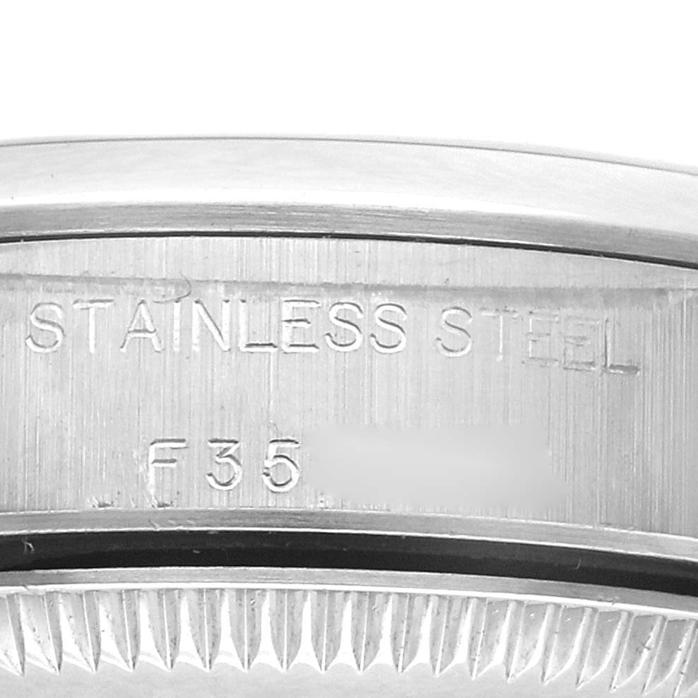 The image shows a close-up of the back case of a Rolex Oyster Perpetual 76080 Women's Stainless Steel Silver Dial 76080 Women's Stainless Steel Silver Dial, highlighting the "STAINLESS STEEL" engraving.