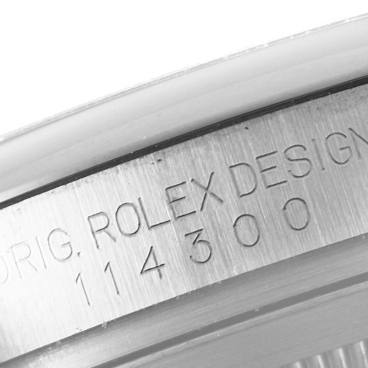 This close-up image shows the model number and design engraving on the case of a Rolex Oyster Perpetual 114300 Men's Stainless Steel Burgundy Dial 114300 Men's Stainless Steel Burgundy Dial watch.