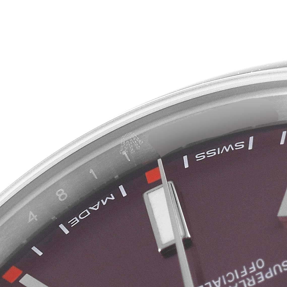This image shows a close-up angle of the dial and bezel of a Rolex Oyster Perpetual 114300 Men's Stainless Steel Burgundy Dial 114300 Men's Stainless Steel Burgundy Dial watch, focusing on the "Swiss Made" text.