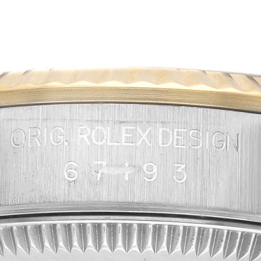 The image shows the side of the Rolex Oyster Perpetual 67193 Women's Steel and Gold (two tone) Champagne Dial 67193 Women's Steel and Gold (two tone) Champagne Dial, highlighting the bezel and engraved case details.