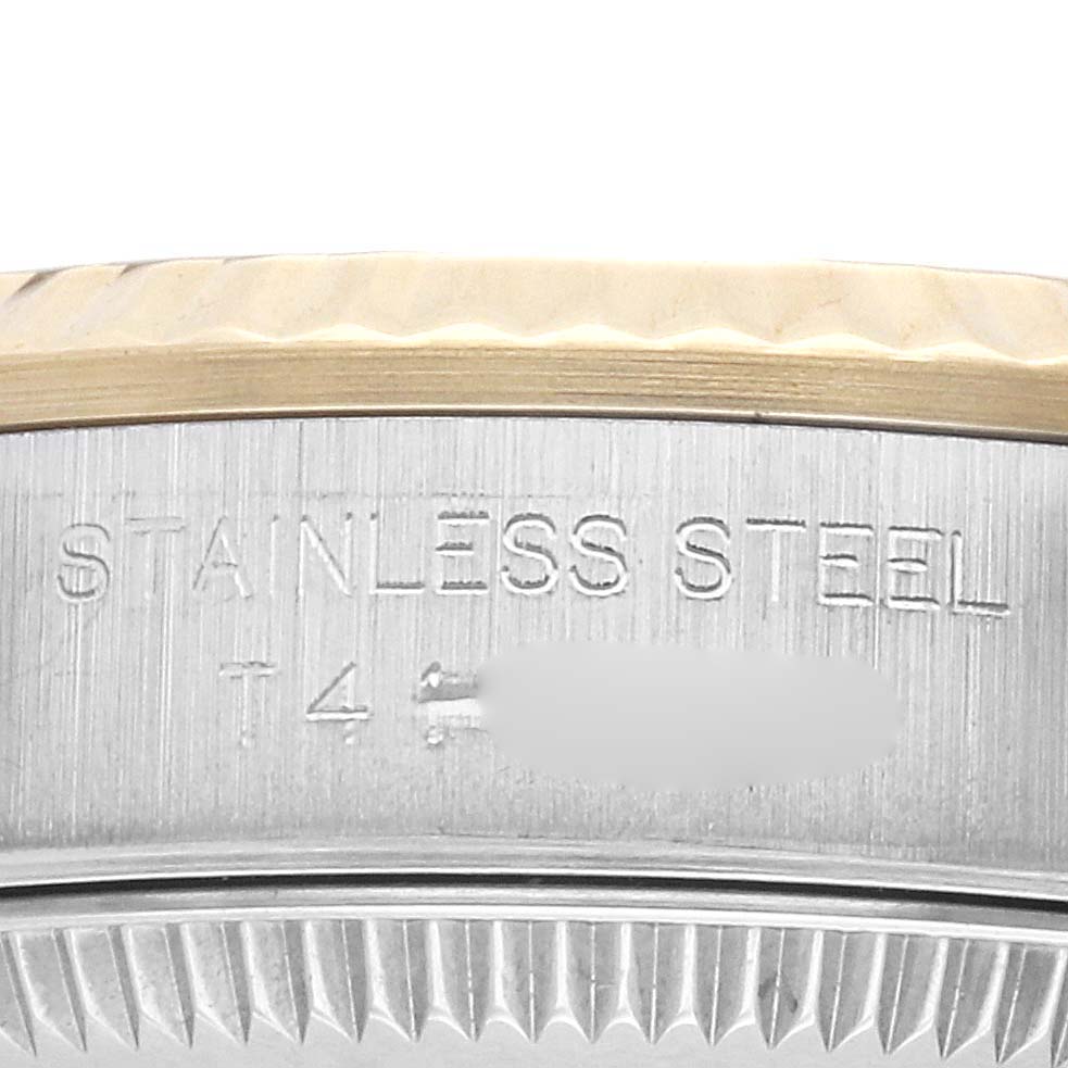 The image shows a close-up of the edge of a Rolex Oyster Perpetual 67193 Women's Steel and Gold (two tone) Champagne Dial 67193 Women's Steel and Gold (two tone) Champagne Dial watch case featuring the stainless steel engraving.