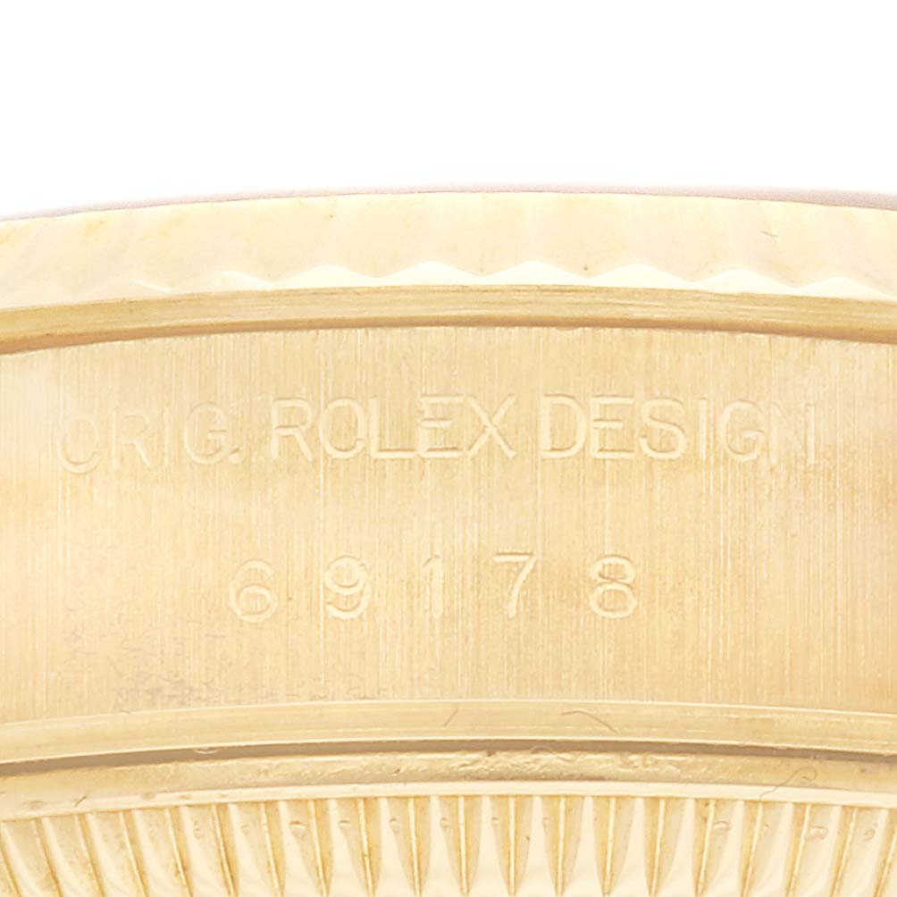 The image shows a close-up of the side of a Rolex President 69178 Women's Yellow Gold Champagne Dial 69178 Women's Yellow Gold Champagne Dial model, focusing on the engraved design details.