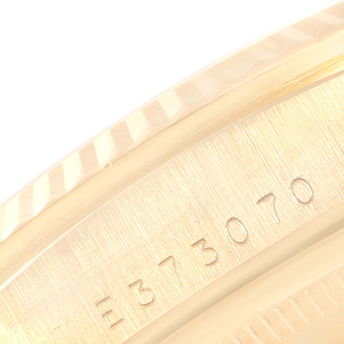 This close-up image shows the side of the bezel and part of the serial number of a Rolex President 18238 Men's Yellow Gold Champagne Dial 18238 Men's Yellow Gold Champagne Dial model watch.