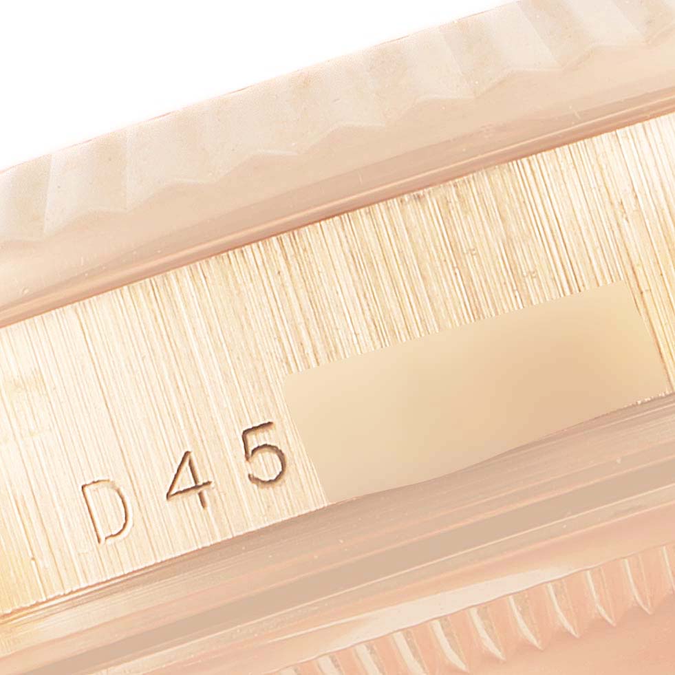 The image shows a close-up of the case side of a Rolex President 118235 Men's Rose Gold Mother of Pearl Dial 118235 Men's Rose Gold Mother of Pearl Dial model, revealing part of the fluted bezel and serial number.