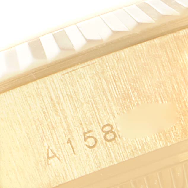 The image shows a close-up of the Rolex President 79178 Women
s Yellow Gold Mother of Pearl Dial 79178 Women
s Yellow Gold Mother of Pearl Dial model, focusing on the side of the case with part of the fluted bezel and engraved serial number.