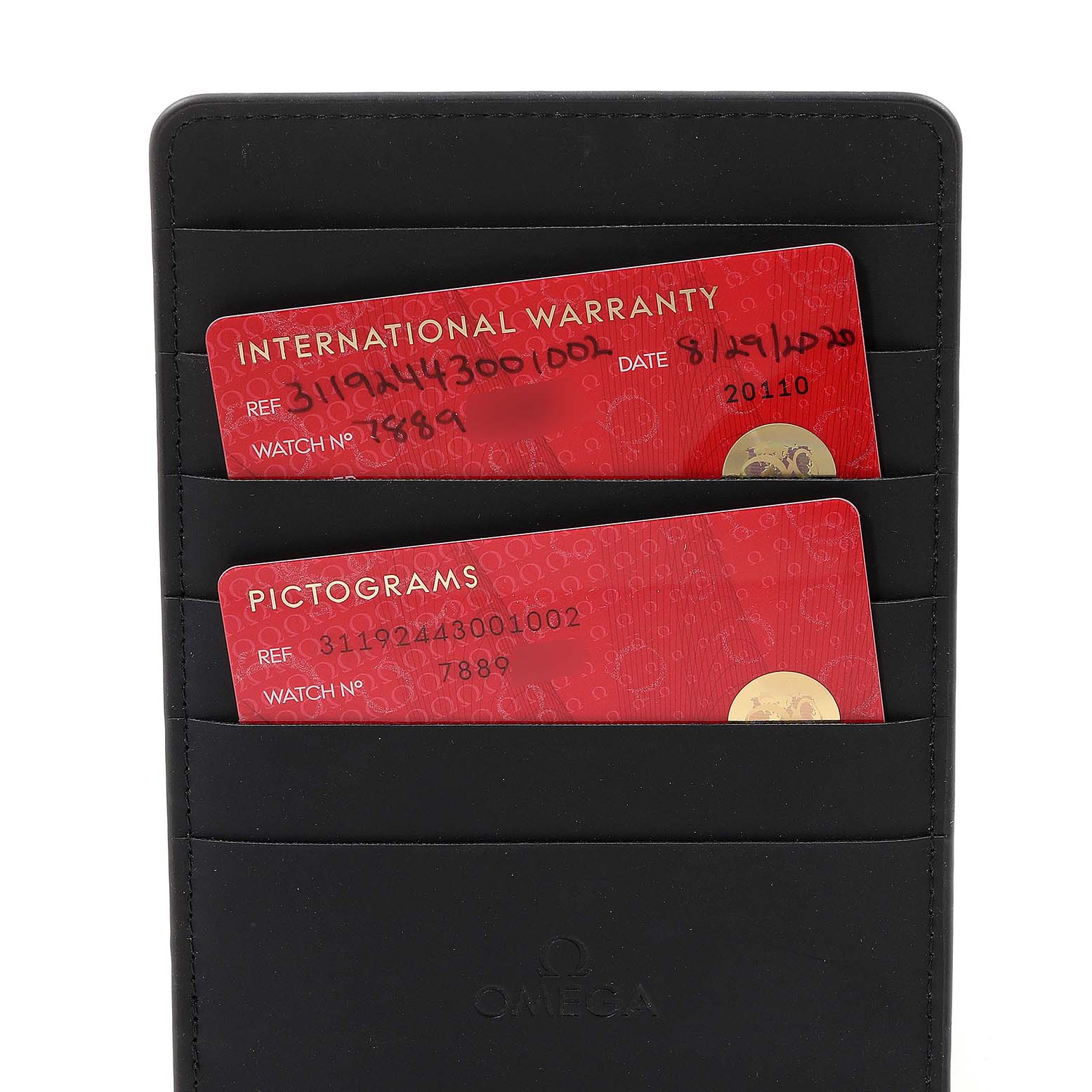 The image shows the international warranty and pictogram cards for an Omega Speedmaster 311.92.44.30.01.002 Men's Ceramic Black Dial 311.92.44.30.01.002 Men's Ceramic Black Dial watch, held in a black cardholder.
