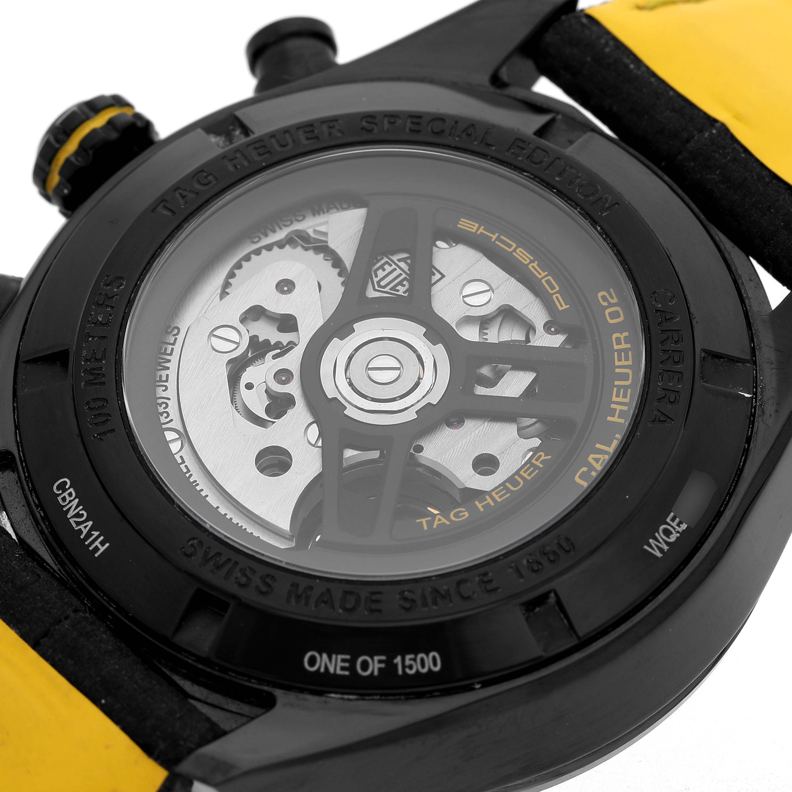 The image shows the back of the Tag Heuer Carrera CBN2A1H Men's Stainless Steel Black Dial watch, highlighting the exposed movement and inscriptions on the case back.