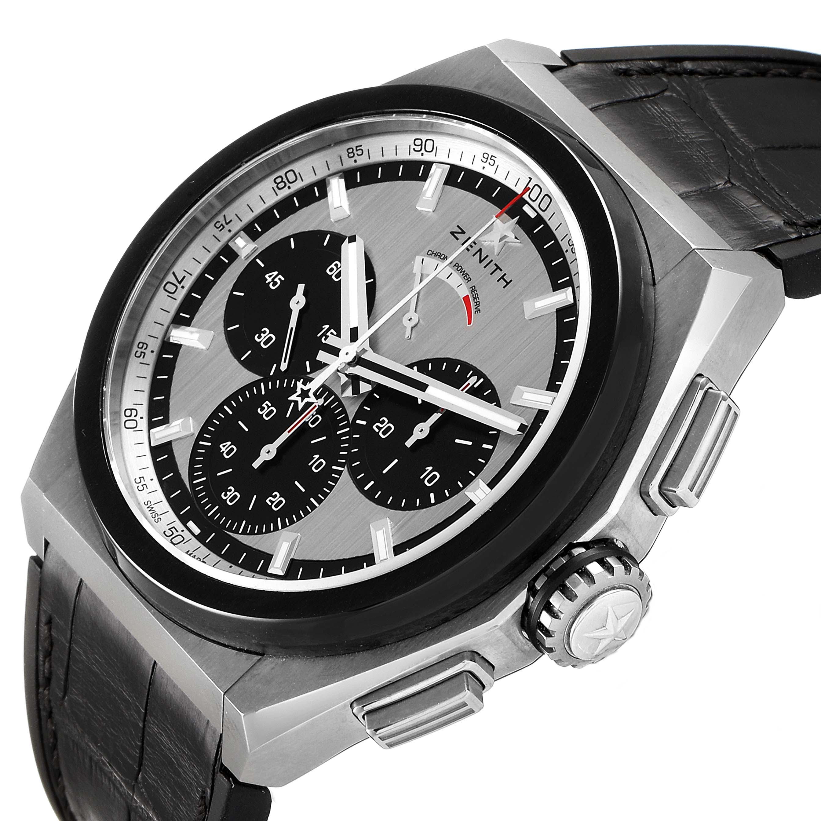 The Zenith Defy 95.9005.9004/01.M9000 Men's Titanium Grey Dial 95.9005.9004/01.M9000 Men's Titanium Grey Dial watch is shown at an oblique angle, highlighting its black dial, chronograph subdials, and leather strap.