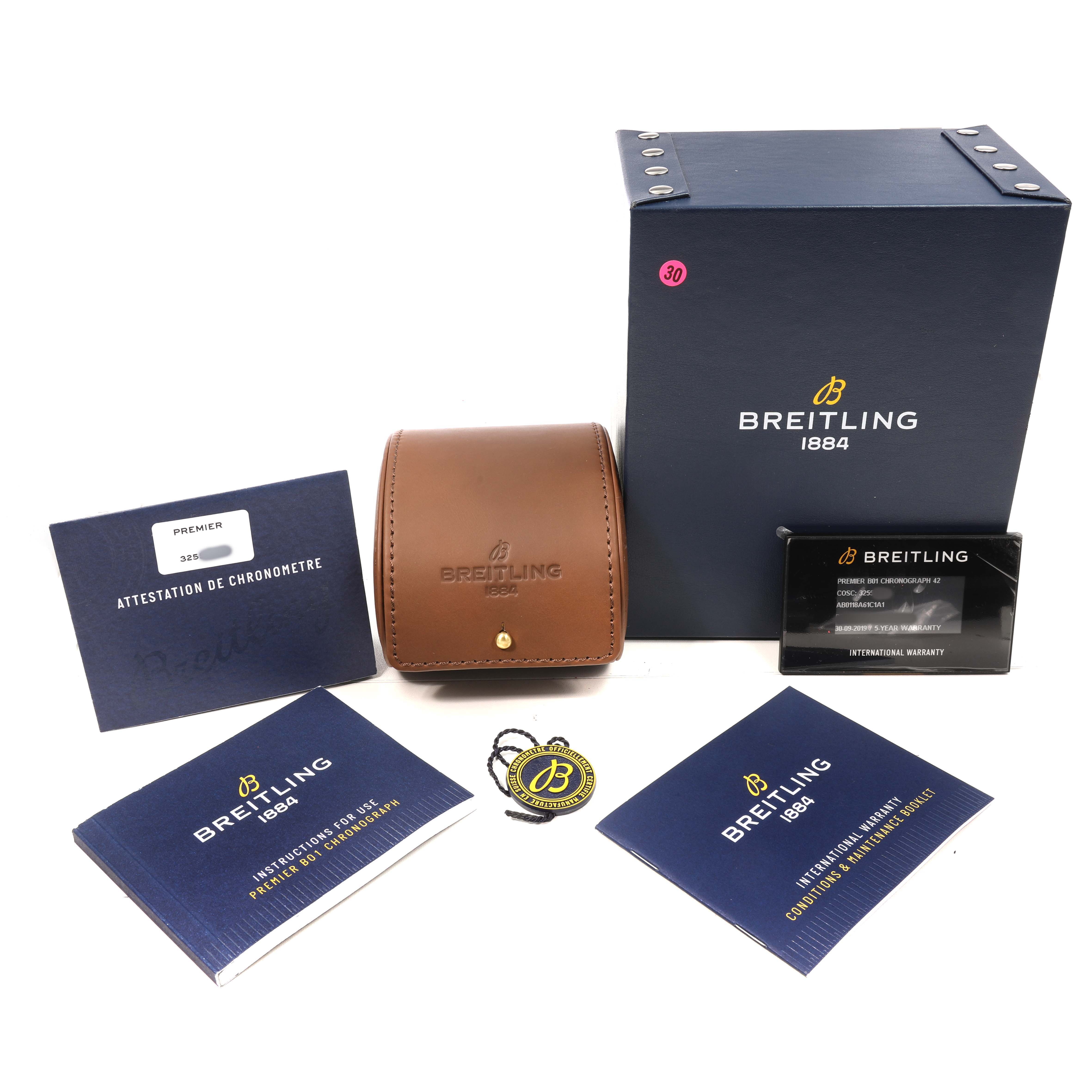 The image shows a Breitling Premier AB0118 Men's Stainless Steel Blue Dial watch box, leather case, manuals, warranty card, and a tag, all displayed from above.