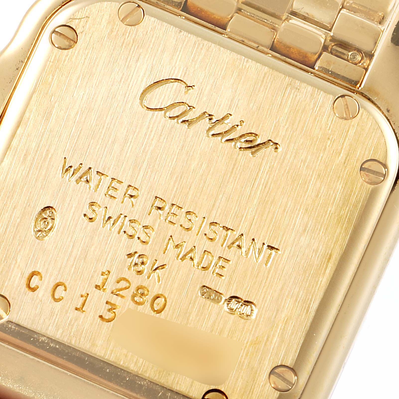 The image shows the back case of a Cartier Panthere 1280 Women's Yellow Gold Silver Dial 1280 Women's Yellow Gold Silver Dial watch, displaying its engravings and screws.