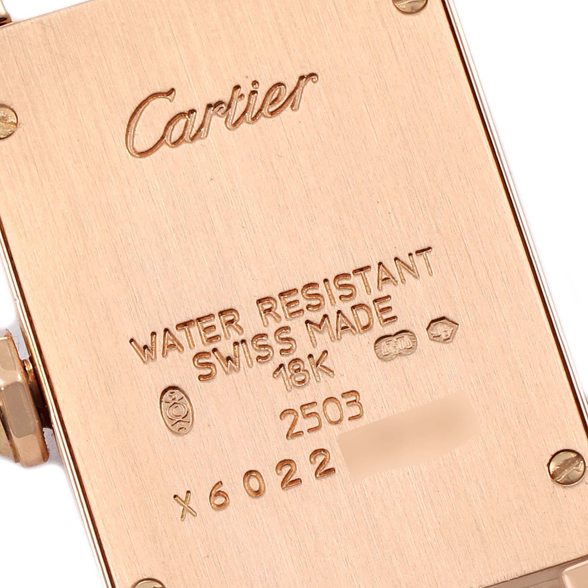 This image shows the back casing of a Cartier Tank Americaine WJTA0002 Women
s Rose Gold Silver Dial WJTA0002 Women
s Rose Gold Silver Dial watch, highlighting its engravings and hallmarks.