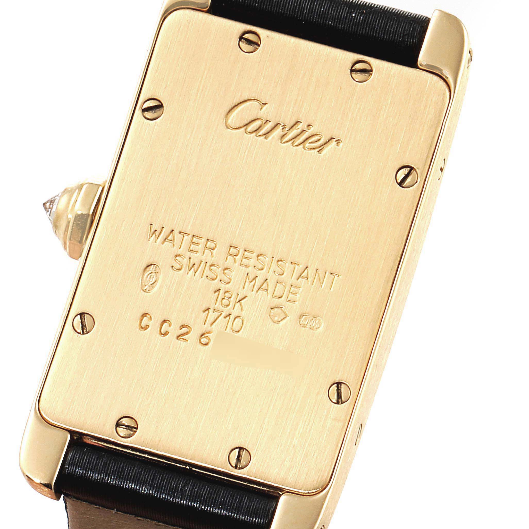 The image shows the backside of the Cartier Tank Americaine 1710 Women
s Yellow Gold Silver Dial 1710 Women
s Yellow Gold Silver Dial watch, highlighting its case details and markings.