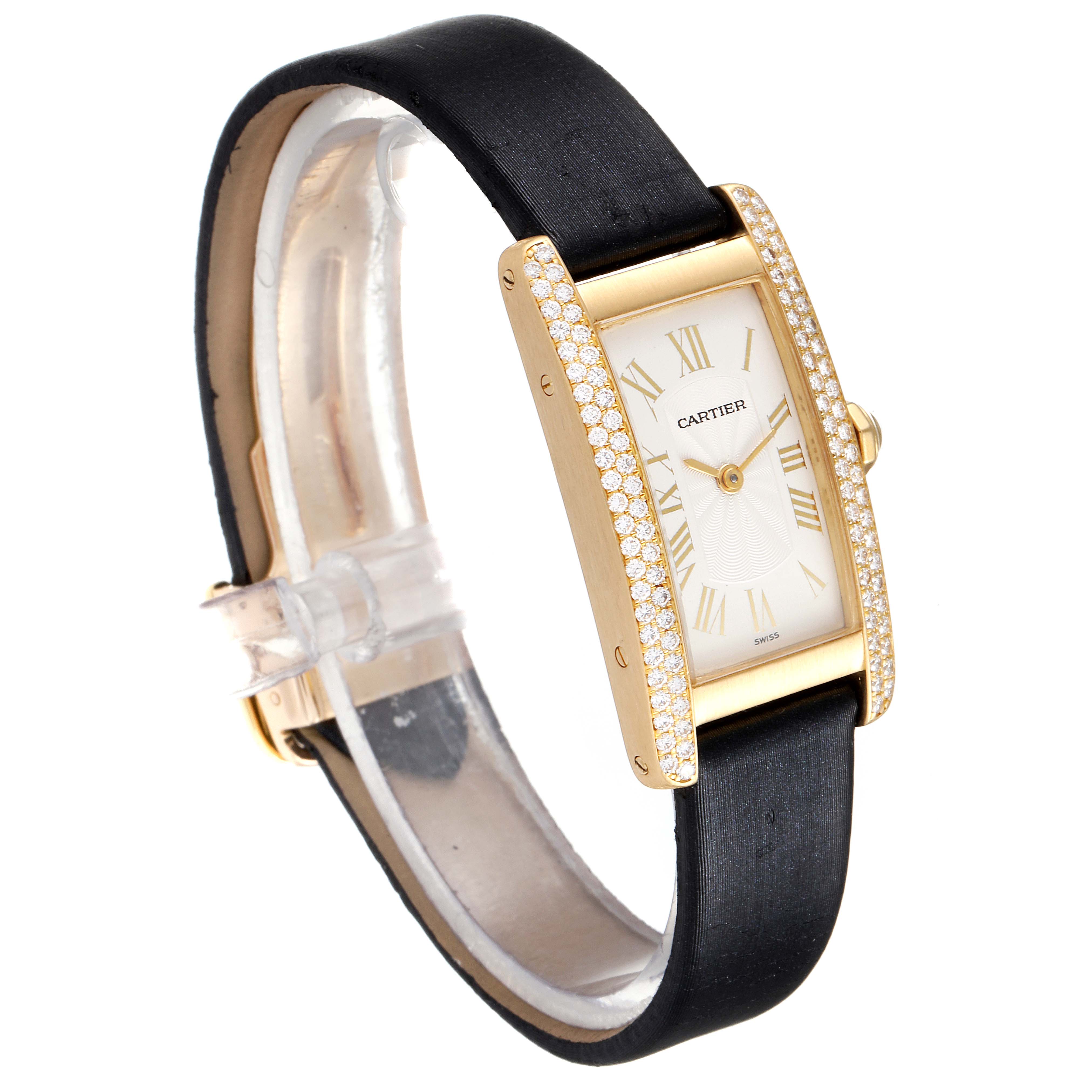 The image shows a Cartier Tank Americaine 1710 Women
s Yellow Gold Silver Dial 1710 Women
s Yellow Gold Silver Dial watch at a slight side angle, displaying its rectangular face, diamond bezel, gold casing, and black strap.
