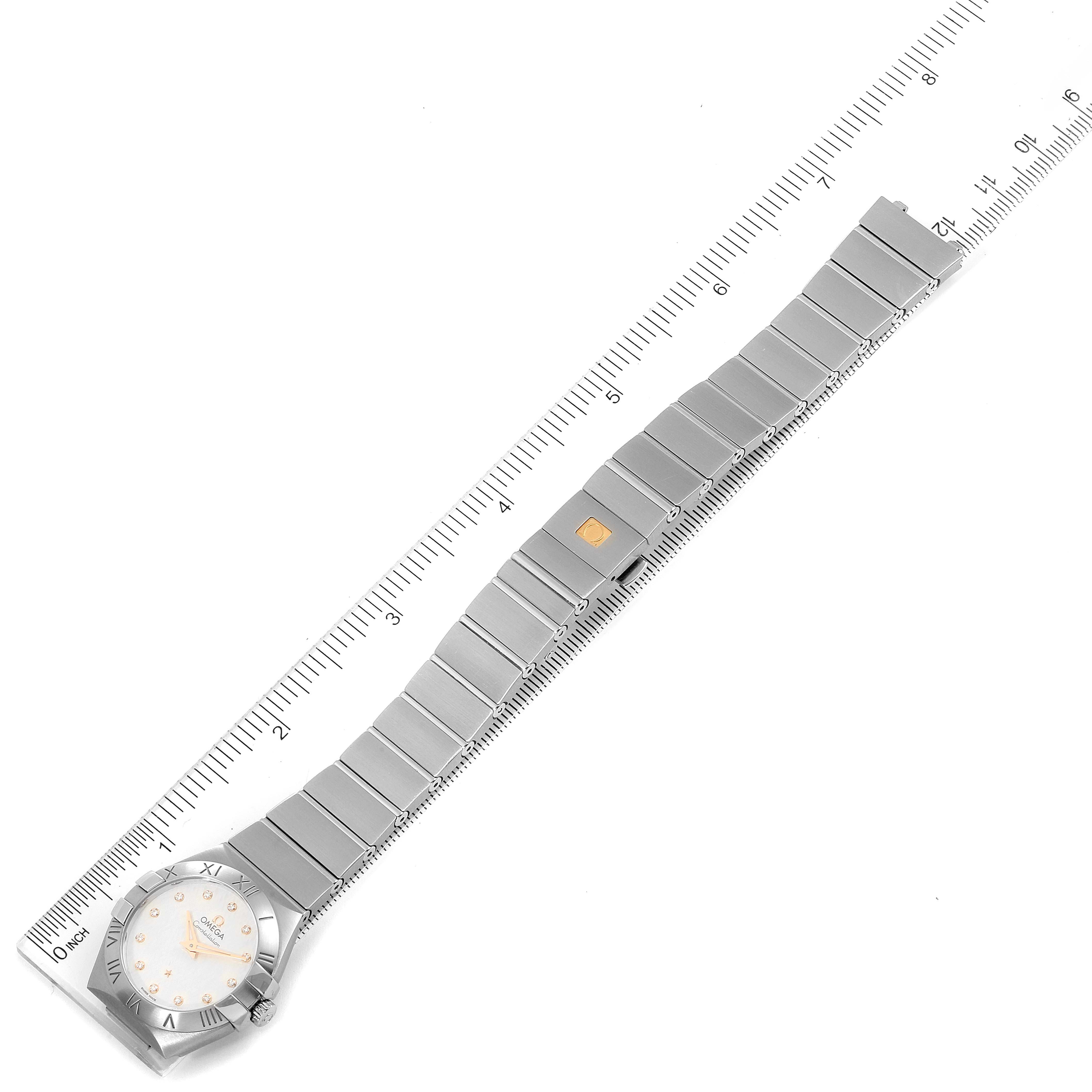 This image shows an Omega 123.10.27.60.52.001 Women
s Stainless Steel Silver Dial 123.10.27.60.52.001 Women
s Stainless Steel Silver Dial Constellation 27mm Diamond Steel Ladies Watch model 123.10.27.60.52.001 positioned flat with a ruler.