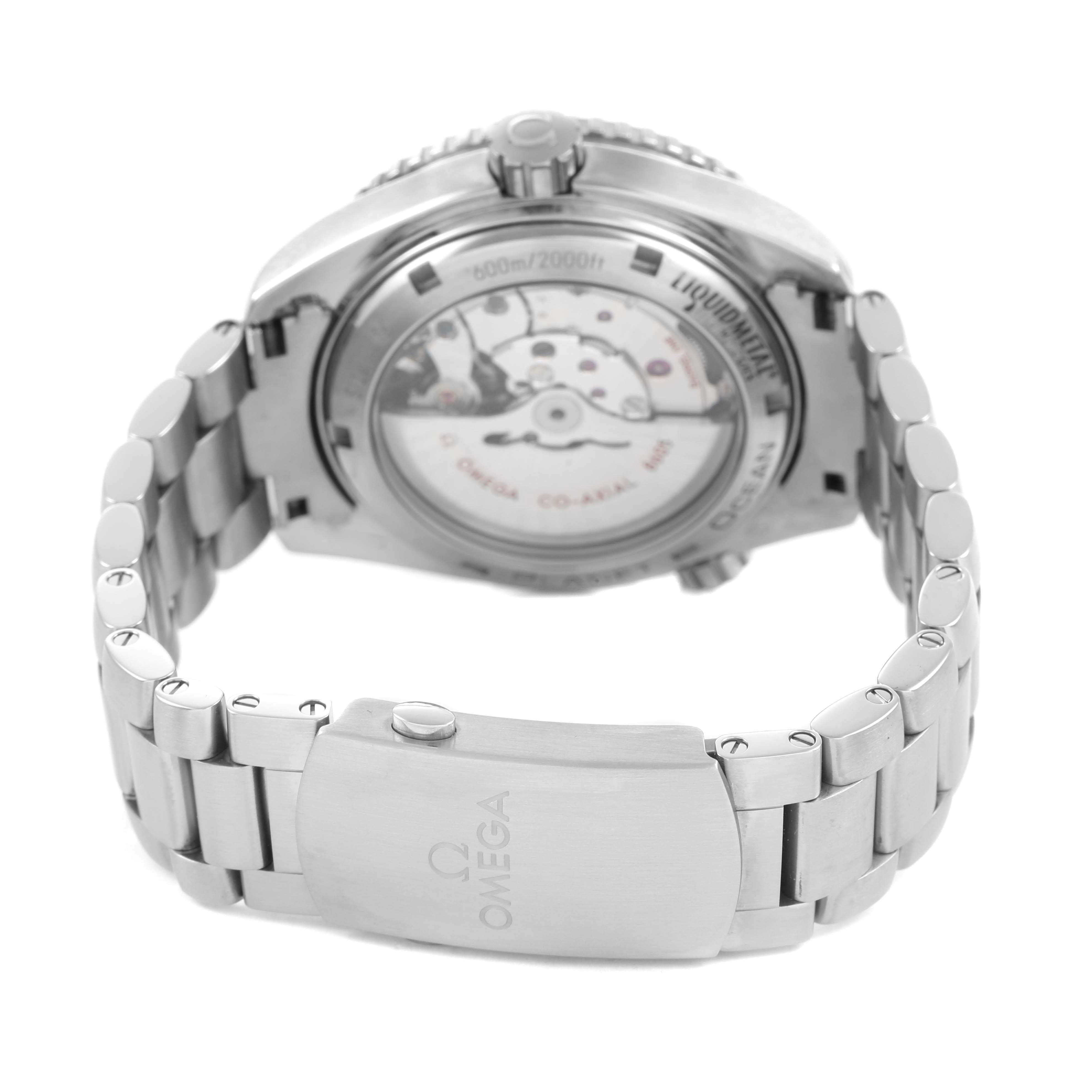 The image shows the back angle of the Omega Planet Ocean 232.90.44.22.03.001 Men's Titanium Blue Dial watch, highlighting the transparent case back and the metal bracelet clasp.