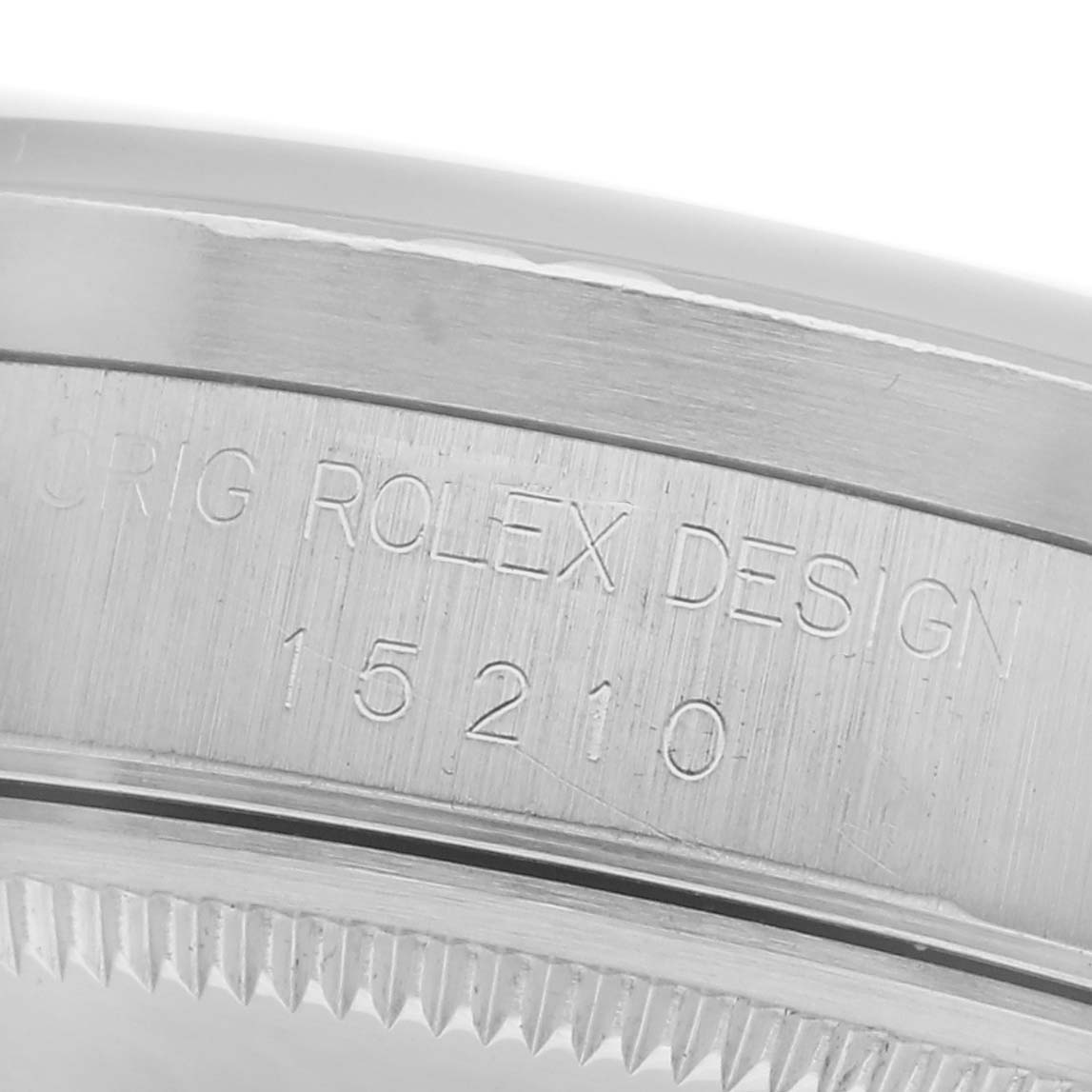 The image shows a close-up of the side case of a Rolex Date 15210 Men
s Stainless Steel Silver Dial 15210 Men
s Stainless Steel Silver Dial model, highlighting the engraved serial number and design details.