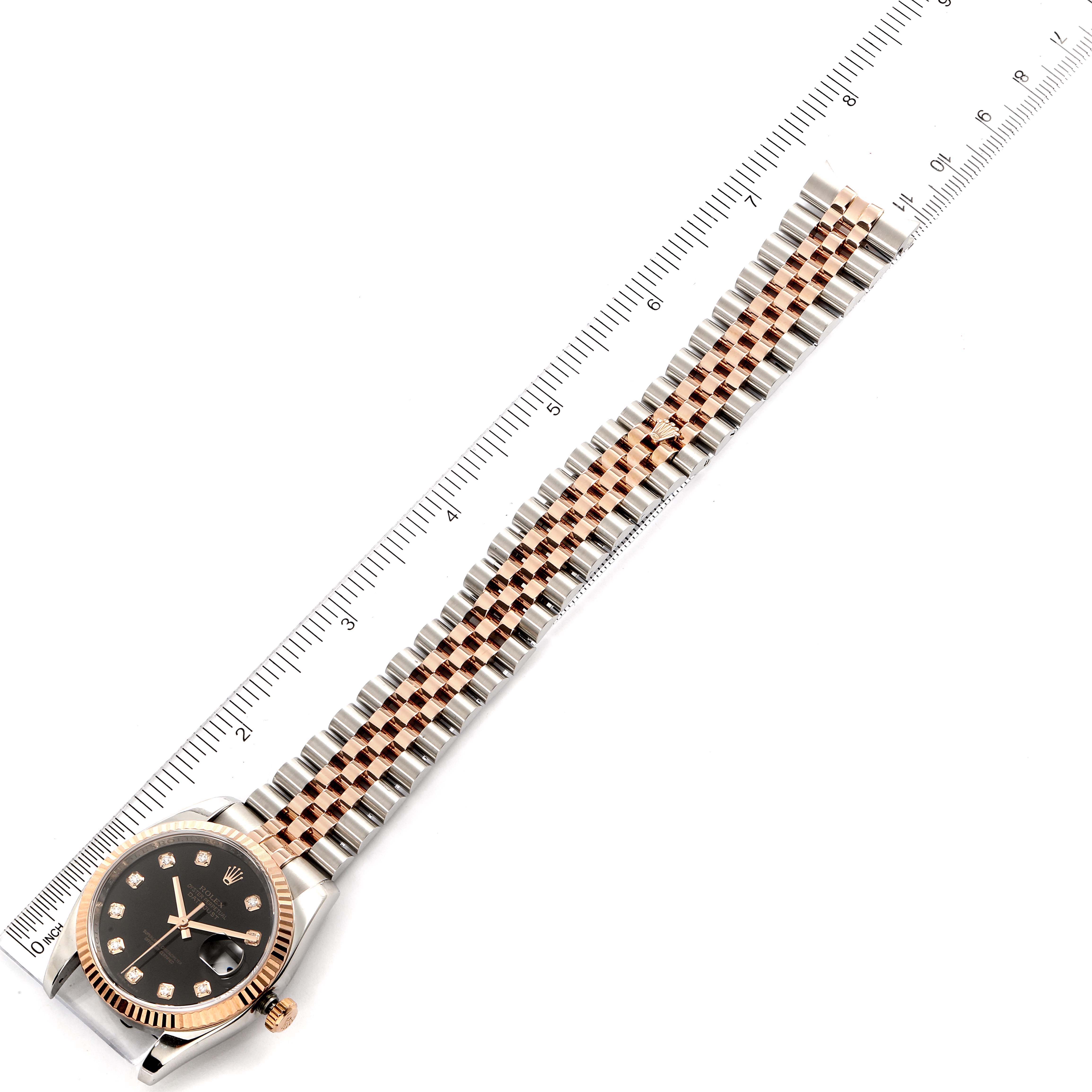 This image shows a Rolex Datejust 116231 Men's Steel and Gold (two tone) Black Dial 116231 Men's Steel and Gold (two tone) Black Dial watch from an overhead angle, highlighting the face, bezel, and metal bracelet alongside a ruler.